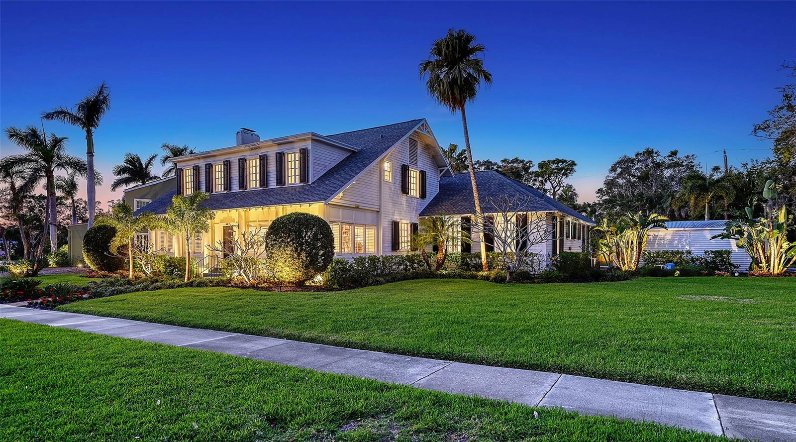 Step into history and timeless elegance at the House of Ringling, a landmark estate in Sarasota's coveted Whitfield Estates, built in 1918 for Alfred Ringling of the legendary Ringling Brothers. Spanning 4,782+/- sq. ft., this 5BR, 4.5BA masterpiece seamlessly marries Gilded Age opulence with modern luxury. A red brick walkway and expansive front lawn welcome you to this architectural treasure, where an oversized Grand Ballroom with a 21-foot ceiling, Venetian columns and a Renaissance-style coffered ceiling create an awe-inspiring focal point. Original pine floors, 12-inch baseboards and hand-poured antique glass in French windows and doors preserve the estate’s rich craftsmanship, as the
reimagined chef’s kitchen is a showpiece, featuring Big Chill appliances, an 8-burner gas stove, Quartzite surfaces, a mother-of-pearl backsplash and backlit cabinets. The primary suite on the lower level offers floor-to-ceiling French doors opening to a private porch and the expansive pool deck. Upstairs, 2 ensuite bedrooms feature partial bay views. Hidden details, including a prohibition-era speakeasy/3rd bedroom at the top of the stairs and a secret room, add intrigue and charm. The home’s walls, crafted from Ringling railway car paneling, echo its storied past. Recent updates, including new plumbing, electrical, HVAC (5 units), and a new roof with extra tie-down straps, ensure modern comfort while preserving historic character. A detached 2-car garage and 2 driveways provide ample space, while the expansive Palm Beach-style courtyard invites relaxation. As one of the first Ringling Brothers homes in Sarasota, this estate offers a rare opportunity to own a living piece of history in a prime location near Sarasota Bay and downtown.