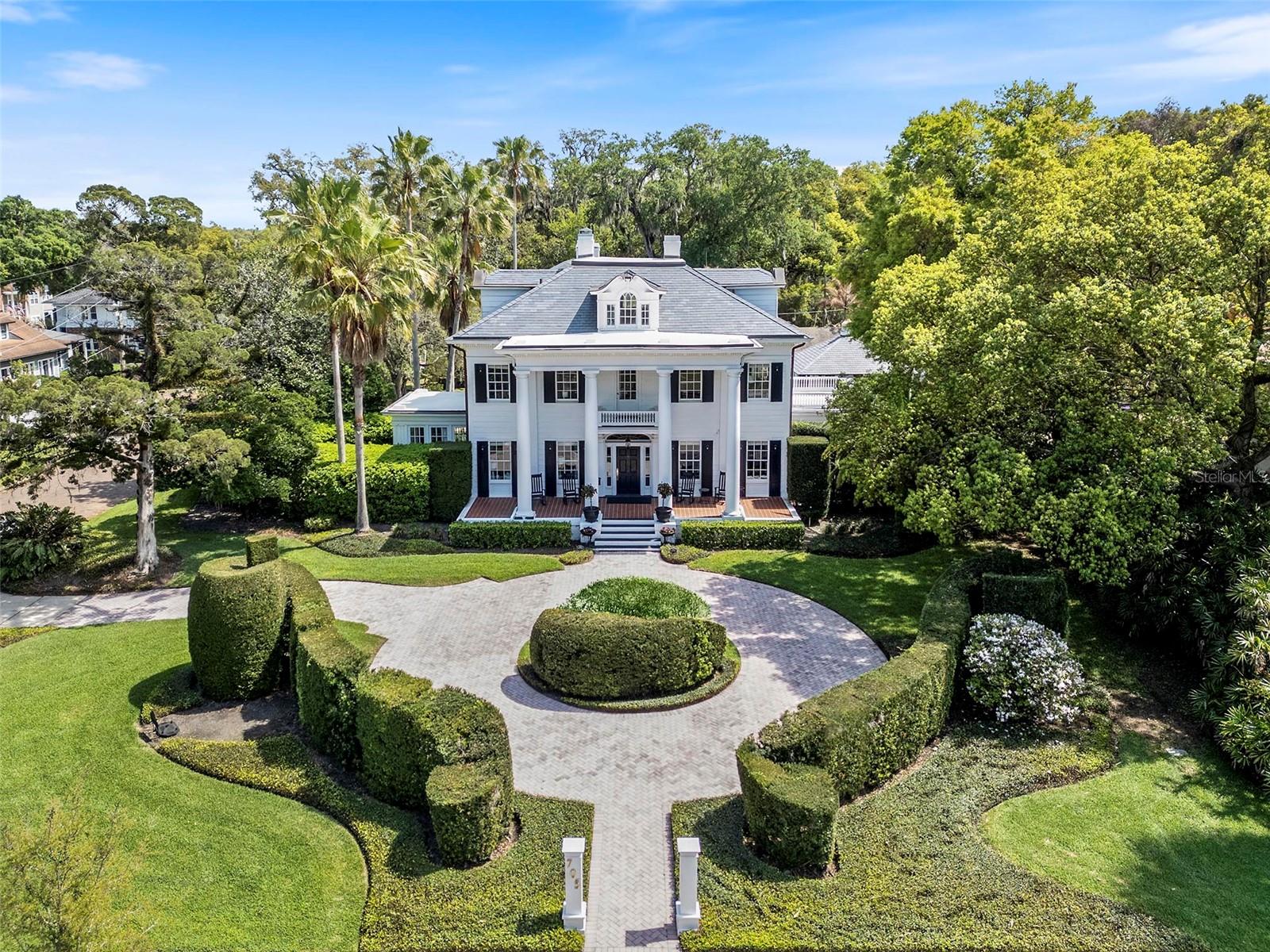 One of Orlando’s signature homes in the Cherokee Historic District, this extraordinary estate exudes elegance and timeless grandeur, offering a resort-style pool, private guest house and expansive grounds in one of downtown’s most coveted neighborhoods.

Set on an oversized lot (.56 acres), this stately three-story, 18-room residence offers an impressive blend of scale, craftsmanship and thoughtful updates. A dramatic oval, handcrafted three-story staircase creates a striking first impression in the grand black-and-white marble foyer, flanked by formal living and family rooms designed for both elegant entertaining and comfortable living. The living room extends into a light-filled sunroom, ideal as a private office or studio, while the family room opens to a screened porch with slate flooring, seamlessly connecting indoor and outdoor spaces.

The chef’s kitchen is both functional and refined, featuring an oversized island, Wolf convection gas range, Sub-Zero refrigeration with additional drawer units, custom cabinetry, and purified drinking water. Overlooking the beautifully refinished pool and outdoor entertaining areas, the kitchen flows effortlessly into a well-appointed summer kitchen, perfect for hosting.

Interior details reflect exceptional character and craftsmanship, including wood flooring throughout most of the home, decorative ceiling elements, picture rails, brass antique light switches, and a wood-burning fireplace. The spacious primary suite features soaring ceilings and a large bath with an oversized shower and distinctive metal sinks. A secondary staircase and basement level-with updated laundry, dual washers, drying area, and laundry chute-add both charm and functionality.

Extensive recent improvements totalling over $200,000 enhance both beauty and peace of mind, including a new slate roof (2024), copper gutters and soffits, updated flat roofs, new insulation, upgraded electrical and multiple HVAC systems, along with a tankless water heater for the main house and separate for the guest house.

The outdoor setting is equally impressive, with mature landscaping, a motor court, two-car garage, and a private one-bedroom guest house complete with full kitchen and bath. Additional features include Tesla charging capability and a prepaid termite bond.

Ideally located just minutes from downtown Orlando, within walking distance Restaurants, Farmers market, Arts festivals, Dr. Phillips Center for the Performing Arts and less than a mile from Orlando Health ORMC, the home offers both convenience and prestige.

Originally built for Dr. and Mrs. John S. McEwan, among early Orlando’s most prominent families and featured on the cover of Orlando Magazine in 1923, this residence is a rare legacy property, thoughtfully maintained and updated to meet the standards of today’s most discerning buyer while preserving its rich architectural heritage. Furnishings may convey with acceptable contract. Home has been pre-inspected.