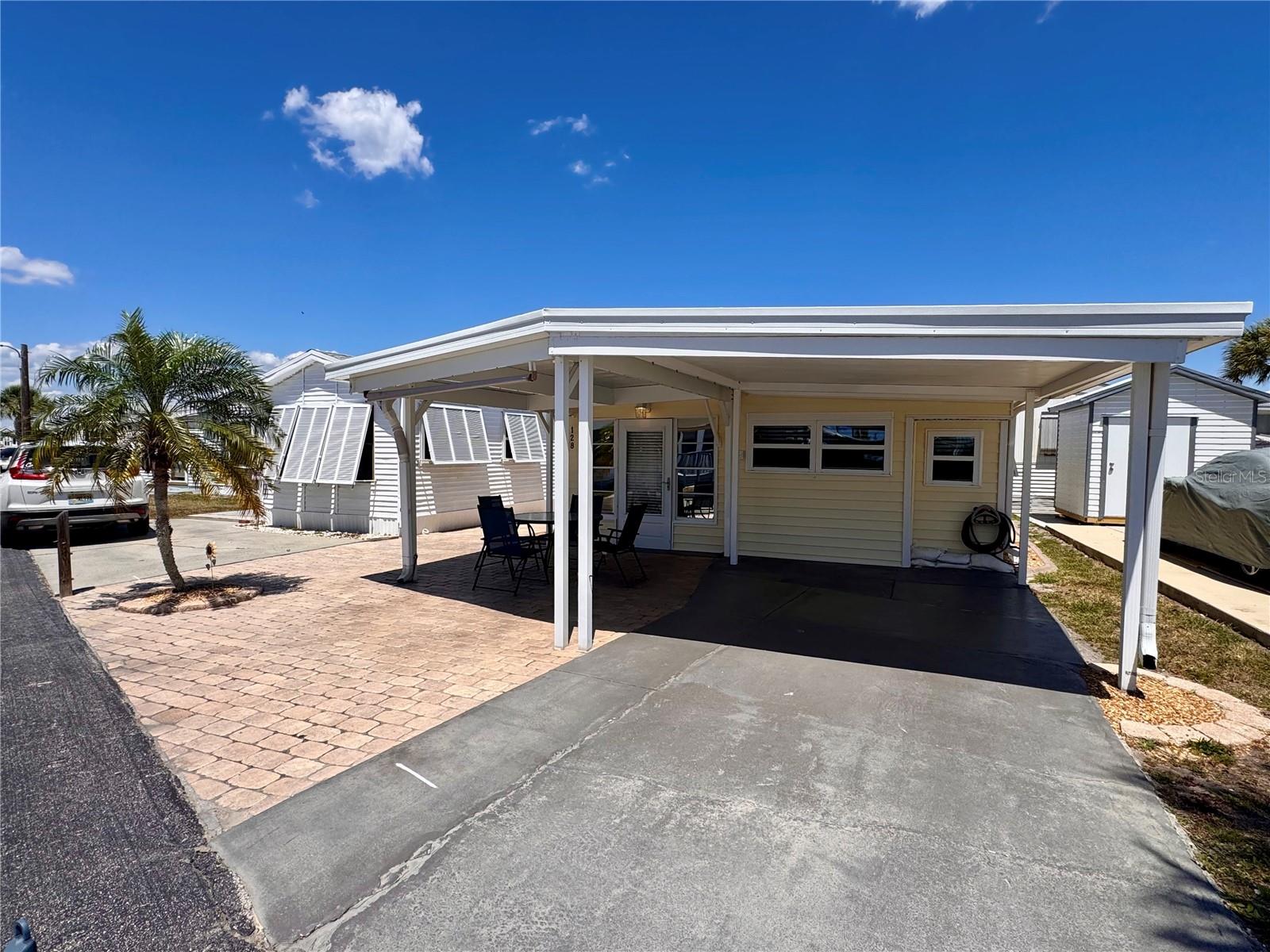 Welcome to the "Coastal Cottage Retreat" - a meticulously updated, TURNKEY FURNISHED residence in the gated community of Holiday Travel Park, where YOU OWN THE LAND! Golf cart and RV friendly, this charming home blends comfort, style, and an unbeatable Florida lifestyle. A standout feature is the rare 21’ x 21’ covered front patio, offering an incredible shaded outdoor living space—perfect for morning coffee, evening cocktails, and soaking in those stunning Florida sunsets. Inside, this move-in ready 2-bedroom, 2-bathroom home (588 sq ft) has been thoughtfully upgraded with a new metal roof (2023), A/C (2021), hot water heater (2023), newer double-pane windows on the front and right side, plantation shutters in the dining room and both bedrooms and new carpet in the living room. The kitchen is both functional and stylish, featuring granite countertops and a modern stone tile backsplash. You’ll also appreciate the abundant storage, interior laundry room, and a shed/workshop with electric—perfect for hobbies or extra space. On city water and city sewer! Holiday Travel Park offers low HOA fees ($140/month) that includes water/sewer, a heated community pool, lawn maintenance, an active clubhouse with social events, pool tables, indoor pickleball and a scenic kayak launch with a peaceful freshwater lake setting. RV/boat storage onsite for $100 annually. Located less than 10 minutes from Manasota Key, you’ll enjoy easy access to beautiful Gulf beaches including Englewood Beach, Stump Pass State Park, Middle Beach, and Manasota Beach. Pet-friendly—one pet allowed up to 40 lbs. Don’t miss your chance to own this slice of coastal charm—schedule your showing today and start living the Florida lifestyle you’ve been dreaming of!