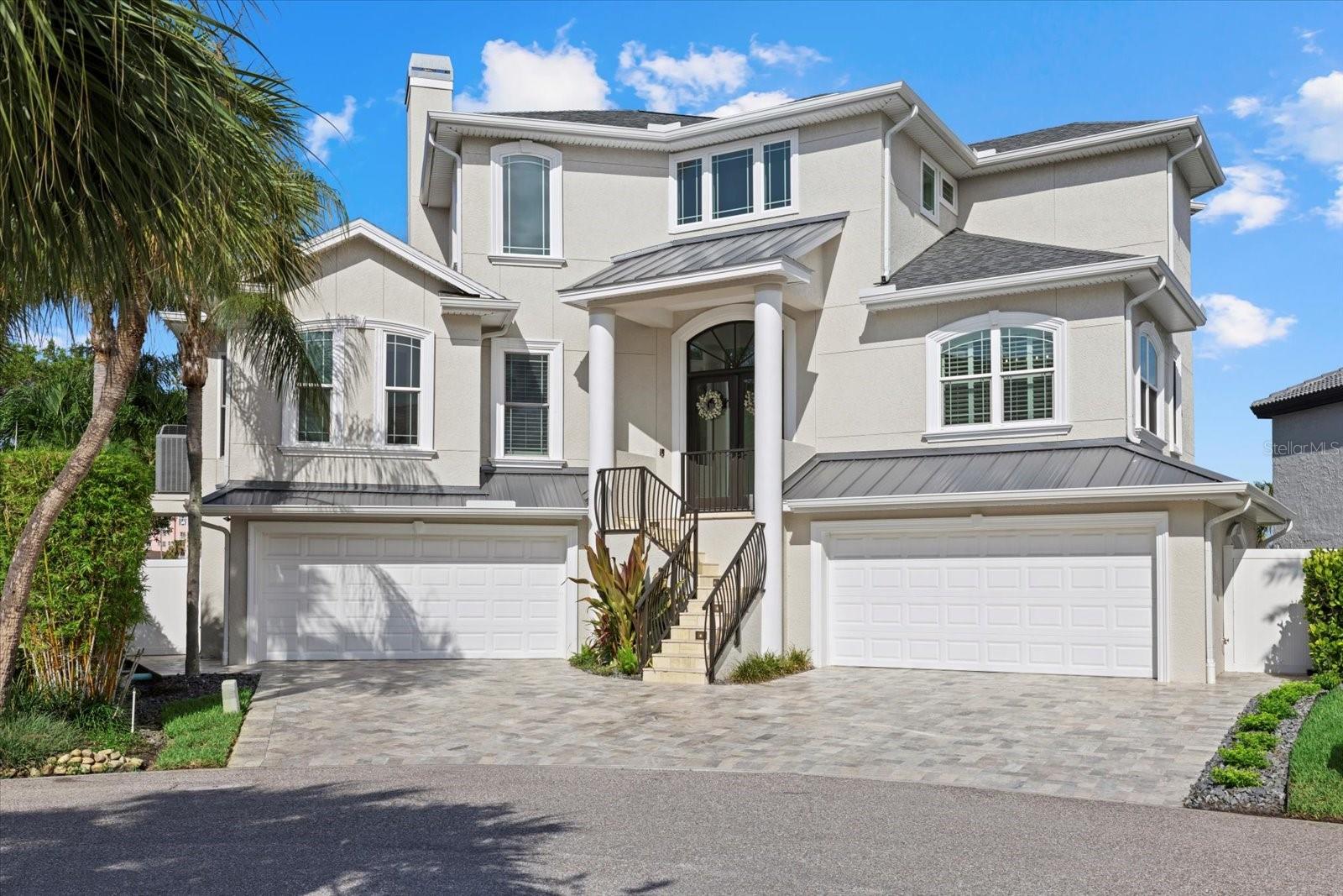 Sunset Bliss awaits you on St Pete Beach! Escape to one of St Pete Beaches most coveted locations. This Magnificent 4-bedroom 3 full bathroom residence stands as a testament to sophistication. Enjoy a boaters paradise with open water right to the Gulf Of Mexico that offers a 20,000 Lb boat lift. This home is nestled  in a well-established and sought after Cul-de-Sac on Mangrove Point Dr. Step inside to see 21-foot soaring ceilings that allow beams of light to enter throughout your main living space. For the discerning chef, the kitchen is a real showstopper. Stainless steel appliances gleam including a double oven, glass cooktop, a massive Kitchen- Aid refrigerator, microwave, dishwasher and wine/drink refrigerator. Quartzite natural stone countertops and wood cabinets frame this amazing kitchen. There is new tile throughout the home for simple living and cleaning. Fresh new paint, all new plumbing and lighting fixtures and newly remodeled bathrooms with quartz counters and wood cabinets are throughout. The living room has a cozy fireplace for you to use on cool winter nights. Recessed lights give a nice clean look to the ceilings. Ascend upstairs using the grand staircase to the primary bedroom retreat. Here you will find massive walk-in closets for your couture collection, his and hers vanity sinks with a large walk-in shower, and a private toilet room with a bidet. The primary retreat has it's own lanai to watch fabulous sunsets over the Don Cesar hotel, and as the sun sets, hues of crimson and gold paint the sky. The bedroom has its own indoor lounge/reading area for quiet relaxation and inspiration.  Safety and peace are paramount in knowing that all windows and patio doors are newer, and hurricane rated. Close to 500K has been invested on this amazing property for renovations and it is shown in every room. The heated pool outside, bubbling hot tub, and its expansive paver lanai is perfect for entertaining your guest. Feel free to sip champagne, and let the Florida sun Kiss your skin while sunbathing. This entire pool space is fully remodeled with all new pool resurface materials and pavers. Four zone heating and air units ensure comfort year-round, allowing you to adjust the temperature wherever you wish for a balmy summer evening or a crisp winter night.  The roof is under 3 years old and appointed with durable metal and shingle materials. Fresh neutral paint was completed on the inside and outside of the home, so you can just move right in. There is plenty of beautiful lush landscaping that surrounds the residence. Pull into the EXTRA LARGE 4 car garage for all your prized vehicles and tools. An additional storage space is there for your extra treasures. You're going to love the bonus room on the lower level that is approximately 1,500 sq feet. It is heated and aired to be used as a flex space for a workout room, hobby space, artist studio, or whatever you wish to use it for. The beach with it's powdery sand is only blocks away from this home with a private entrance and parking area for residence of this cul-de- sac. Downtown St Pete is only 12 minutes away and you are close to restaurants, quaint shops and grocery stores located within 5 minutes. The Pinellas Bayway is minutes away and Tampa airport is only 35 minutes away. St Pete/Clearwater Airport is approximately 20 minutes away and you are right up the road to Pass-A- Grille. For Leisure pursuits, Lazarillo Park beckons. Roof installed in Sept 2021.