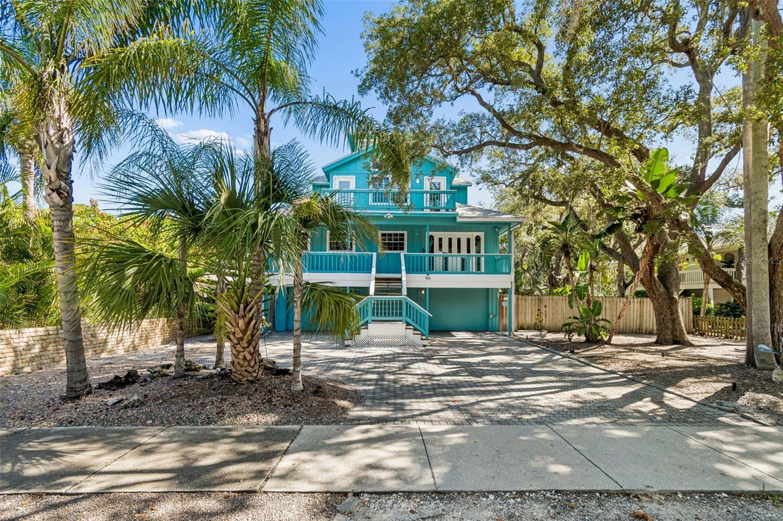 Welcome to 416 Tennessee Avenue, a distinctive Coastal Contemporary retreat nestled beneath majestic oak trees in the charming waterfront village of Crystal Beach.
Step back in time and discover a community where neighbors meet at the post office, gather along the shoreline, and at local events. Rich in history and tucked away in North Pinellas County, Crystal Beach offers a slower pace of life, breathtaking nightly sunsets, and direct access to the Gulf Waters & Pinellas Trail. It is a lifestyle and atmosphere that must be experienced to be truly appreciated.

From the moment you arrive, the home's curb appeal captures your attention. Painted a striking nautical blue and accented by a brick paver driveway, this four-story residence offers abundant parking and exceptional architectural character.

This property offers 4 rooms and 2 full baths. The 4th room can be used as a loft, office or easily converted to the 4th bedroom to suite your family.

The exterior staircase leads you up to the spacious veranda, where coastal breezes welcome you home. Enter through custom stained-glass double doors into a light-filled great room floor plan featuring impressive White Oak luxury vinyl flooring throughout. Surrounded by windows, every room enjoys peaceful treetop views that create a unique treehouse-like setting.

The gourmet kitchen, beautifully remodeled in 2022, is truly a chef's delight. Features include leathered stone countertops, premium stainless-steel appliances, a convenient microwave drawer, breakfast bar seating, and a custom built-in dining nook. Just off the kitchen, another private veranda provides the perfect setting to enjoy morning coffee while watching the sunrise over the treetops.

A stunning floating staircase leads to the luxurious primary suite and office on the 4th level. The spacious owner's retreat features soaring ceilings, a beautifully remodeled spa-inspired bath with soaking tub, separate shower, dual vanities, and charming nautical-inspired finishes. A custom-designed walk-in closet system provides exceptional storage and organization. New windows and sliding glass doors open to a private veranda, creating your own elevated sanctuary among the trees.

Continue upward to the crowning jewel of the home—a charming cupola office and observation space surrounded by windows on all sides.
(4th room for use of your choice) Complete with a dedicated mini-split system, this inspiring retreat offers panoramic treetop vistas and a peaceful environment for work, reading, creativity, or quiet reflection.

The backyard is a private resort-style oasis designed for year-round Florida living. Enjoy the heated swimming pool, outdoor shower, expansive brick paver patios, and wood decking that blend seamlessly into the thoughtfully designed xeriscape landscape.

The oversized garage offers exceptional flexibility with two bays, including one tandem parking bay, plus an additional climate-controlled 18' x 22' room with endless possibilities as a fitness studio, workshop, game room, art space, home business, or guest overflow area. Convenient access to the backyard further enhances the functionality of this versatile space.

If you've been searching for a home that combines architectural charm, modern updates, outdoor living, and the unmatched Crystal Beach lifestyle, your search may be over. Come experience the coastal village lifestyle you've been dreaming about!