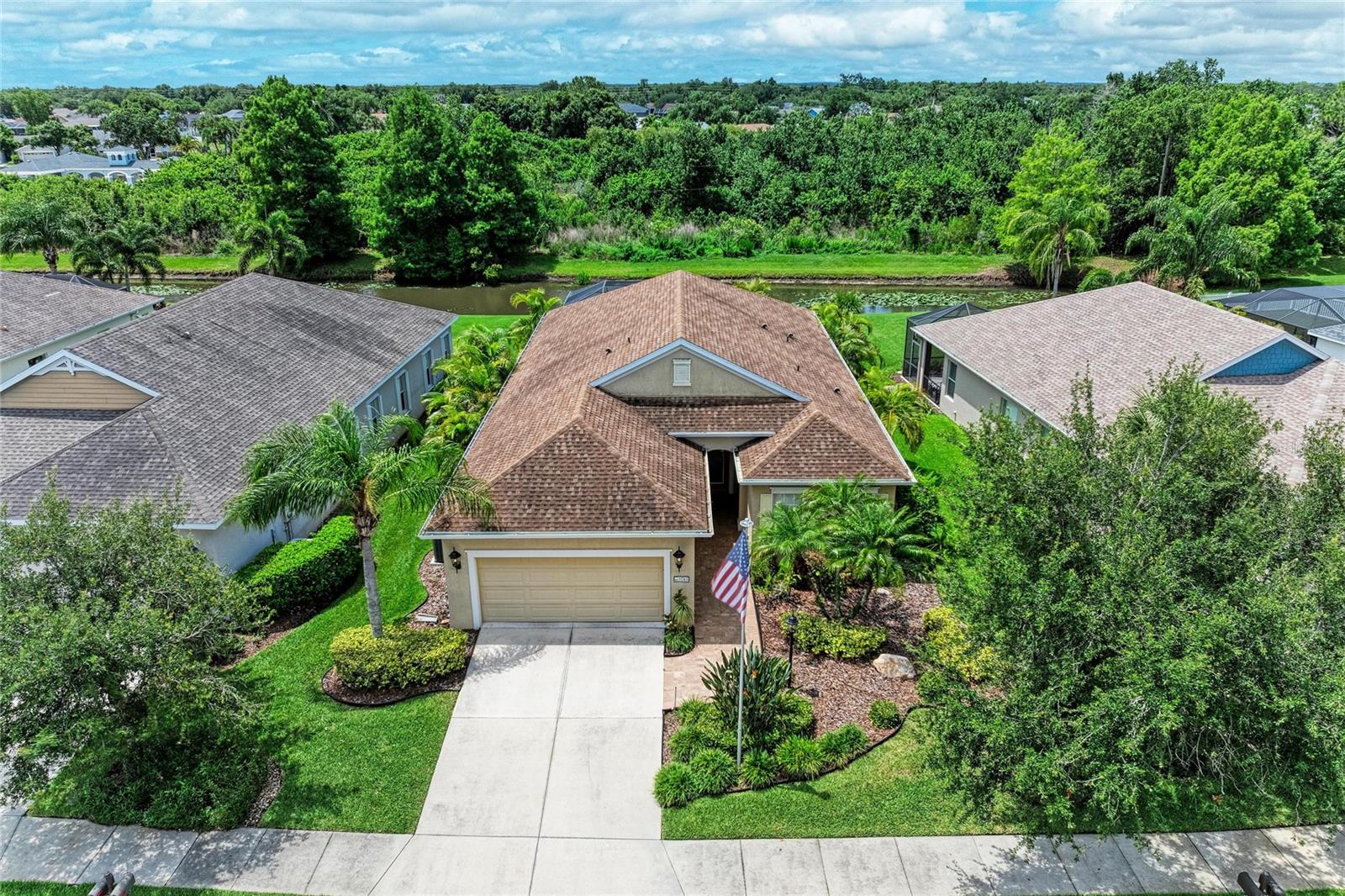 One or more photo(s) has been virtually staged. Welcome to this beautiful 3-bedroom, 2-bathroom home located in the highly sought-after gated community of Forest Creek. From the moment you arrive, you'll appreciate the attention to detail, beginning with the full-size flagpole, lush landscaping, and decorative glass front door. Step inside to discover a thoughtfully designed floor plan enhanced by crown molding, tray ceilings, and quality finishes throughout. The home features a formal dining room perfect for entertaining, as well as a dedicated office complete with built-in shelving for added functionality and style. The well-appointed kitchen offers granite countertops, stainless steel appliances, under-cabinet lighting, a breakfast bar, and beautifully crafted cabinetry with crown molding. The spacious primary suite provides a private retreat with dual walk-in closets and an impressive ensuite bath featuring dual sinks, a large tiled walk-in shower, and a private water closet. Other interior highlights include a laundry room equipped with cabinetry, shelving, and a utility wash sink for added convenience. Step outside to the oversized screened lanai with paver flooring—the perfect place to relax and enjoy peaceful pond and wooded views. Additional features include hurricane shutters as well as a retractable screen on the lanai, an irrigation system, and upgrades that make this home truly move-in ready. Residents of Forest Creek enjoy an exceptional lifestyle with resort-style amenities including a heated community pool and spa, two playgrounds, a dog park, scenic walking trails, and an 18-acre lake ideal for fishing and canoeing. Conveniently located with easy access to Tampa, St. Petersburg, and Sarasota, all within approximately 45 minutes, this home offers the perfect combination of comfort, convenience, and community. Don't miss this incredible opportunity to own a beautifully maintained home in one of the area's most desirable neighborhoods!