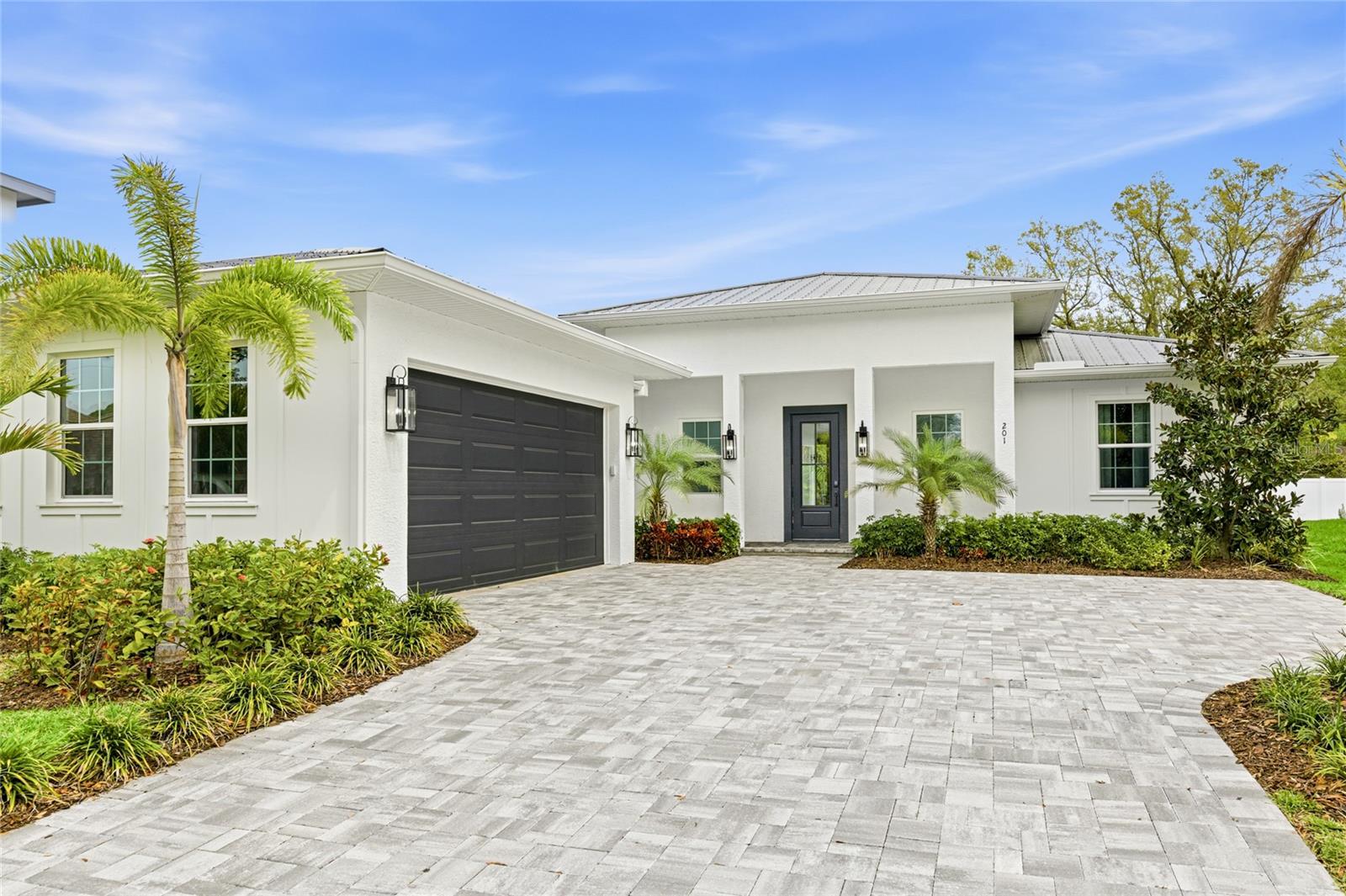 Welcome to this exceptional ONE-STORY, NEWER CONSTRUCTION, 4 Bedroom, 3 Bath home featuring a Saltwater Pool, Lanai, Outdoor Kitchen and oversized 2 Car Garage. Offering over 2500 square feet of luxurious living space, this home is perfect for entertaining and enjoying the ultimate Florida lifestyle. Located in FLOOD ZONE X and just minutes to Downtown Sarasota, this custom-built home boasts all BLOCK construction, a metal roof, maintenance-free aluminum soffits and fascia, Impact Rated Windows, Doors and Sliders, a tankless water heater and a professionally designed custom landscaping package. Interior features have been thoughtfully designed and include 12 ft 8-inch ceilings in the Great Room and Kitchen, 8 ft solid core doors and engineered hardwood floors throughout the home. The well-appointed kitchen is sure to please the most discerning chef with custom wood Shaker Cabinets, an oversized island, Quartz countertops, Z-Line Appliances, double oven, an induction range with custom hood and includes a convenient Dry Bar with floating wood-stained shelves and a wine refrigerator. The Primary Suite is a sanctuary and exudes elegance with tray ceilings, a custom design wall featuring detailed trim work and sliding glass doors providing private access to the outdoor pool and patio oasis. Primary Bath delights with a freestanding soaking tub, an oversized shower with rain head, a makeup vanity and Quartz countertops. Entertain with style in the Great Room complete with fireplace, 50-inch oversized chandelier and wall to wall 8 ft pocketing sliding glass doors opening to the Lanai and Saltwater Pool. 3 additional bedrooms, one featuring a decorative custom accent wall perfect for an office/flex room, are all generously sized with built-in closets. The Laundry Room includes a custom tile floor, built-in cabinets, Quartz countertops and a Samsung Smart washer and dryer. Easy access to Downtown, the Legacy Trail, Payne Park, Sarasota Memorial Hospital, Siesta Key and all area beaches makes this Move-In Ready home a must see! Embrace Sarasota living at its finest!
