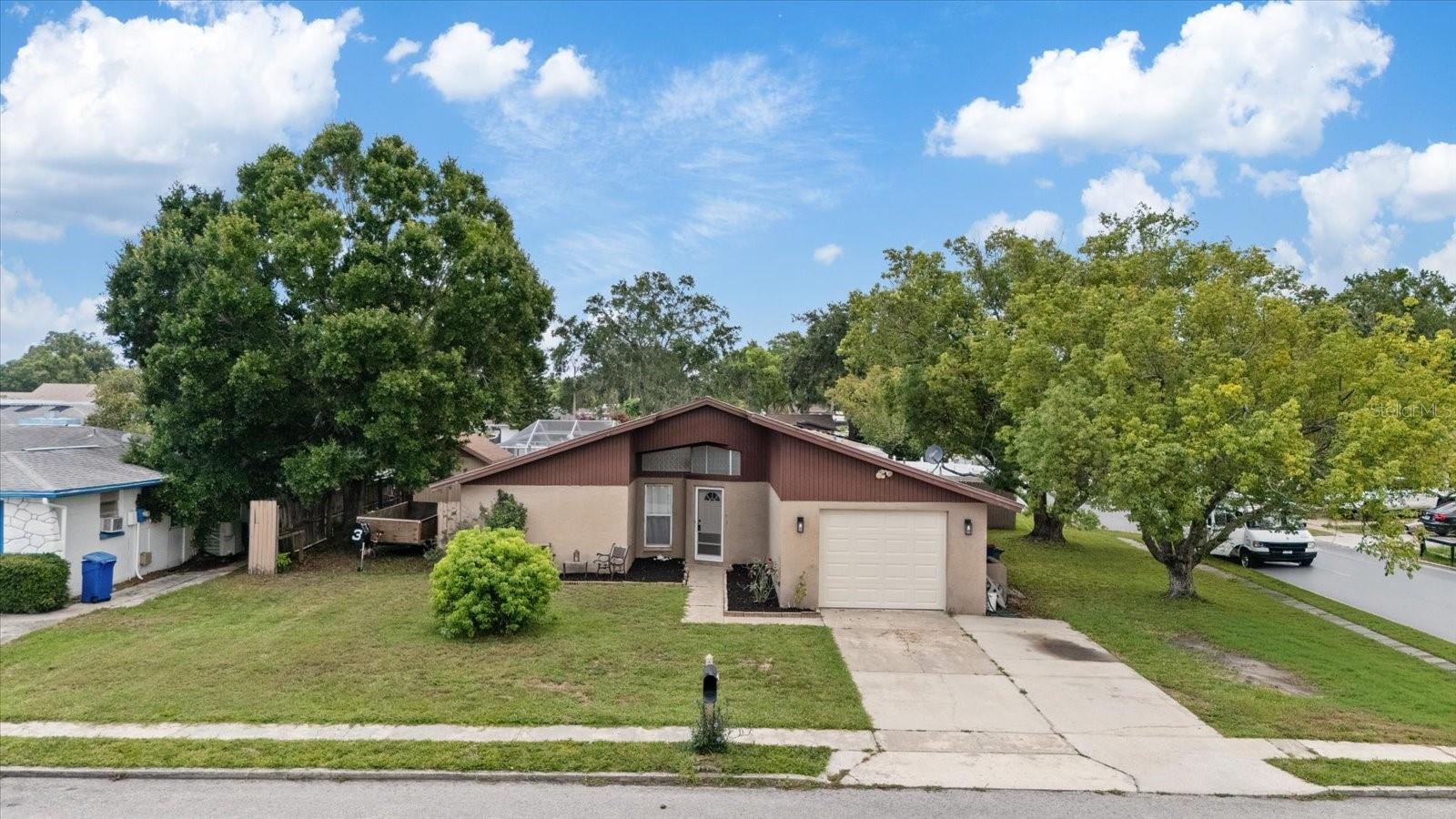 Welcome home to 5632 Lima Drive in Holiday, Florida! This move-in ready 2-bedroom, 2-bath home with a 1-car garage is tucked away on a beautifully shaded corner lot in a convenient Holiday location. From the moment you walk through the front door, you'll love the soaring vaulted ceilings and the wide-open feel that make the home feel much larger than its square footage.

The split-bedroom floor plan offers privacy for family and guests, while the spacious primary suite is the perfect place to unwind. The open kitchen features a breakfast bar, plenty of cabinet space, and a large pantry, making everyday living and entertaining a breeze.

One of the best features of this home is the oversized screened lanai—perfect for enjoying your morning coffee, hosting friends, or relaxing on those cool Florida evenings. The large backyard offers room for pets, gardening, or play, and the large storage shed provides plenty of extra space for tools, lawn equipment, or hobbies. No flood zone and no HOA!

Located just minutes from shopping, restaurants, medical facilities, parks, and the beautiful Gulf beaches, this home truly offers comfort, convenience, and easy Florida living. Whether you're looking for your first home, a seasonal retreat, or a place to downsize, this one is ready for you to move right in. Schedule your private showing today!