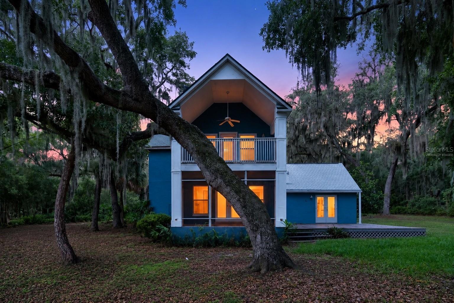 Virtually Staged. Nestled beneath majestic oak trees on a breathtaking 1.98-acre waterfront lot along Long Pond, this charming two-story English Cottage-style home offers a rare blend of character, privacy, and outdoor living. With approximately 560 feet of decking, multiple outdoor gathering spaces including two open porches, a screened porch, and an upper-level deck overlooking the natural surroundings, this property is designed to embrace Florida's beautiful landscape.

Inside, you'll find a warm and inviting interior featuring tile and wood flooring throughout with no carpet, soaring ceilings in the living room, and a cozy wood-burning fireplace that creates the perfect focal point for family gatherings. The spacious kitchen offers a walk-in pantry and opens seamlessly to the main living areas, creating an ideal setting for entertaining.

The owner's suite provides a relaxing retreat complete with a soaking tub, while fresh interior paint gives the entire home a bright, updated feel. Recent improvements include a brand-new septic system installed in late 2025, a roof replaced approximately three years ago, a new well bladder tank (2023), new hot water heater (2024), and a newer dishwasher. The washer was replaced in 2026.

Additional features include ceiling fans throughout and a detached 14' x 22' shed/workshop equipped with electricity and water, perfect for hobbies, storage, or a home-based workspace.

Whether you're enjoying morning coffee on the porch, entertaining guests on the expansive decking, or simply taking in the tranquil waterfront setting, this unique Long Pond property offers a lifestyle that's difficult to find and impossible to forget.