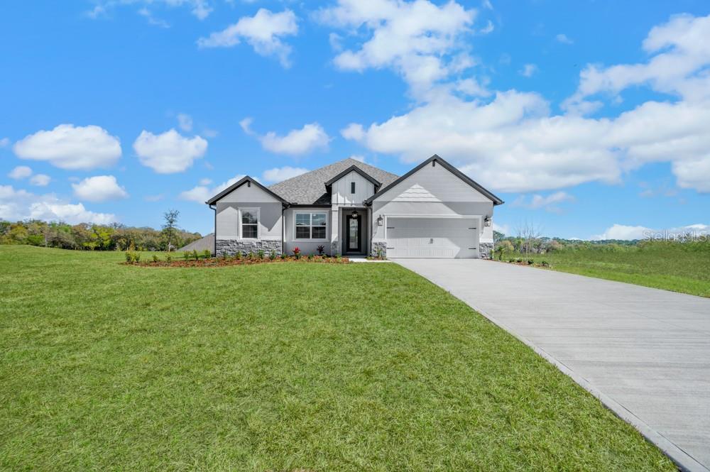 Introducing the Leland at Saddle Hill by Terrata Homes – Fruitland Park

Welcome to the Leland, a beautifully designed four-bedroom, two-bath home located in the brand-new Saddle Hill community in Fruitland Park. From the moment you arrive, the inviting covered front porch sets the tone for a home that feels both warm and thoughtfully designed.

Inside, the foyer opens to an expansive family room that serves as the heart of the home. The kitchen, dining, and family areas blend seamlessly into one cohesive gathering space—perfect for everyday living and entertaining alike. A large center island anchors the kitchen, offering the ideal spot for morning coffee, after-school snacks, or evening gatherings. Quartz countertops, bright white cabinetry, stainless steel appliances, a beautiful tile backsplash, and a spacious pantry combine style and functionality.

Sliding glass doors extend the living space outdoors to a covered outdoor kitchen, creating the perfect backdrop for relaxed evenings and effortless entertaining.

The private owner’s suite is tucked quietly toward the rear of the home, offering a peaceful retreat. The generous bedroom provides ample space for a sitting area or statement furnishings, while large windows invite in soft natural light. The spa-inspired bath features dual vanities, a walk-in shower, and two spacious walk-in closets for exceptional organization. Secondary bedrooms are positioned on the opposite side of the home, offering both privacy and flexibility.



Additional highlights include luxury vinyl plank flooring throughout the main living areas, elevated lighting and plumbing fixtures, clean architectural trim details, blinds throughout, a separate laundry room, a covered front porch, and a two-car garage.

Saddle Hill is nestled among the quiet, tree-lined landscapes of Fruitland Park, offering a peaceful setting with convenient access to everyday amenities. Just minutes away, enjoy the scenic shores of Lake Griffin, beautiful golf courses, charming local cafés, boutiques, restaurants, farmers markets, art walks, and live music events—where small-town charm meets thoughtfully elevated living.

Book and private tour and experience Saddle Hill for yourself.