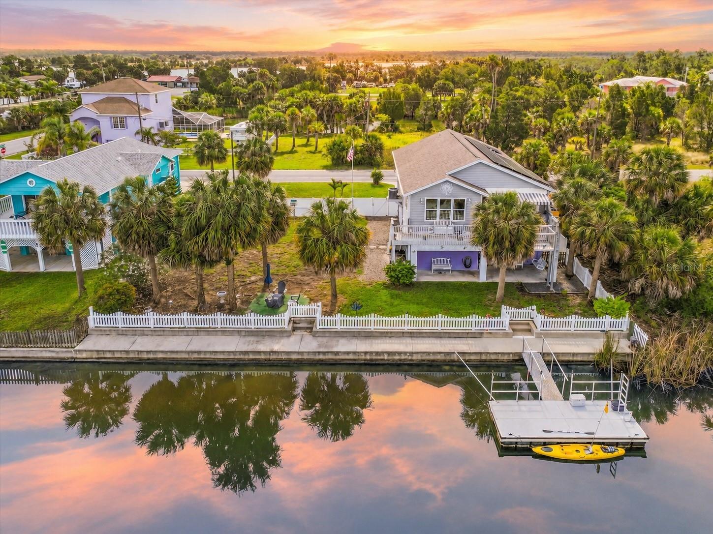WESTERN SUNSET VIEWS, 100 FT OF WATER FRONTAGE & A DOUBLE LOT IN HERNANDO BEACH! This Beautiful 2020-Built Waterfront Home offers the Coastal Lifestyle Buyers are looking for, with a rare Double Lot, 100 feet of Water Frontage, Kneewall & Seawall, Vinyl-Fenced Backyard, 2021 Floating Dock, and a 2023 Outdoor Lift built by Legacy. Enjoy peaceful western views from the rear of the home, where sunsets over the wide waterfront canal create the perfect backdrop for everyday living. Located in a welcoming Hernando Beach neighborhood known for its wide streets, wide canals, and relaxed coastal feel, this property offers access to the saltwater side through the Community Boat Lift, giving you the opportunity to enjoy boating, fishing, kayaking, and the Nature Coast lifestyle. Built in 2020 under newer building codes, this home includes Double-Pane Impact Windows, plus a Solar System to help with electric costs, adding extra value, comfort, and efficiency. Pretty curb appeal welcomes you inside to an Open Great Room Floor Plan with Vaulted Ceilings and Distressed Laminate Flooring in the main living areas for durability and low-maintenance living, creating a light, bright, and spacious feel. The Large Chef’s Kitchen offers plenty of cabinetry and counter space, White Wood Shaker Cabinets, Dovetail Soft-Close Drawers, Granite Counters, Stainless Steel Appliances, and a center Island/Breakfast Bar that opens beautifully to the main living area. The home includes 3 Bedrooms and 2 Bathrooms, with a comfortable layout for everyday living, guests, or a home office option. The Primary Suite features a Walk-In Closet and private bath with White Wood Shaker Cabinetry, Granite Counters, and a Walk-In Shower. Bedrooms 2 and 3 share a Guest Bath with White Wood Shaker Cabinetry, Granite Counters, and a Tub/Shower Combination. The Utility Room includes the Washer and Dryer, adding convenience to the main living level. Outdoor living is easy with the rear porch and awning overlooking the water, while the Vinyl-Fenced Backyard offers plenty of room to create your own Outdoor Oasis with a Pool, Summer Kitchen, Gazebo, Fire Pit, or Expanded Entertainment Area. The HUGE 1,712 sq ft Garage offers incredible storage, workspace, parking, and flexibility, plus Interior Stairs and a Garage Refrigerator. With its Double Lot, wide canal views, sunset exposure, boating access, newer construction, impact windows, oversized garage space, and room to spread out, this Hernando Beach home is a rare opportunity to enjoy waterfront living in one of Florida’s most charming coastal communities.