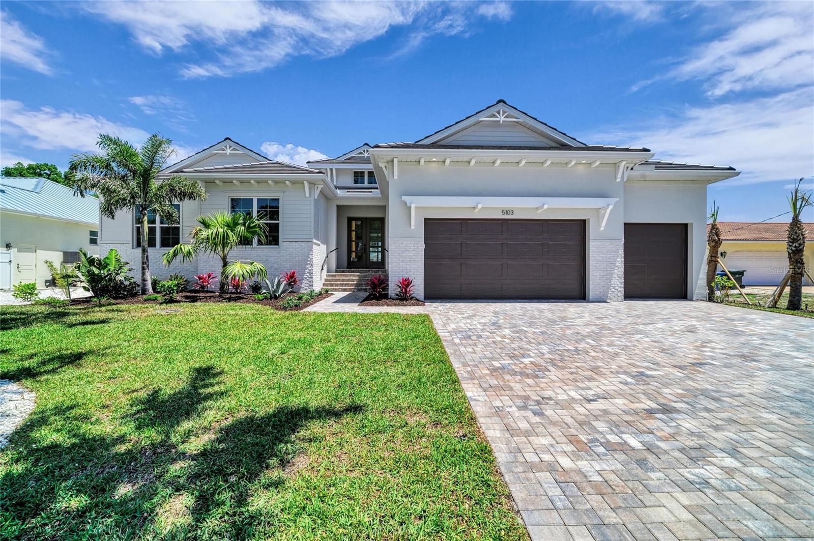 Completed new construction! Built safely and securely ten feet above the island’s flood plain, 5103 Windward is unparalleled new construction with saltwater boating access to the Intracoastal Waterway and Gulf beyond. Along the water’s edge, this homesite spans nearly 1/3 acre on the Grand Canal with 90 ft. of new seawall. The central Siesta Key location makes getting to the spectacular white sand beaches and charming Siesta Village easy and convenient. The free-flowing plan, offering 3,034 sq. ft. of open living, will seduce you with its inviting atmosphere wrapped in casual elegance and modern sophistication. With plenty of natural light, the great room boasts double-height ceilings adorned with rich architectural detail, an elaborate floor-to-ceiling fireplace wall, and see-through views to the expansive outdoor space and coveted canal setting. Beyond the great room’s glass doors, an entertaining lounge with wood ceiling accents, a professional grill station, and a heated pool/spa await your plans for spending cherished time with family and friends. As evening approaches, night lighting transforms the beautiful backyard and creates a timeless ambiance that encourages relaxation and reflection. A gorgeous kitchen is enhanced with an abundance of amenities including a premium Sub-Zero and Wolf appliance package, stone counters, stylized fixtures and finishes, a walk-in pantry, and adjoining laundry. The formal dining room features a built-in buffet and French doors leading to a brick paver patio, making it a wonderful spot for dining alfresco under the stars. The bonus room, with wet bar and pool bath, features two walls of glass sliders showcasing the extensive outdoors and picturesque water views. The primary suite is an oasis of serenity with an office outfitted with built-ins, a generous wardrobe for two, and an exquisite bath intended to pamper and spoil with a free-standing tub, a frameless glass shower with rain head, separate vanities with stone tops, and a water closet. Two additional en-suites offer plenty of room to unwind and rejuvenate in comfortable privacy. A brick paver drive, a 3-car garage, professional landscaping with timed irrigation, eye-catching curb appeal, and other notable customizations inside and out, complete this magnificent waterfront home. This fresh new residence, designed by the award-winning team at Allegra Homes, has been artfully designed and crafted to offer the highest quality to those who live here. An exciting opportunity to make this island paradise yours!