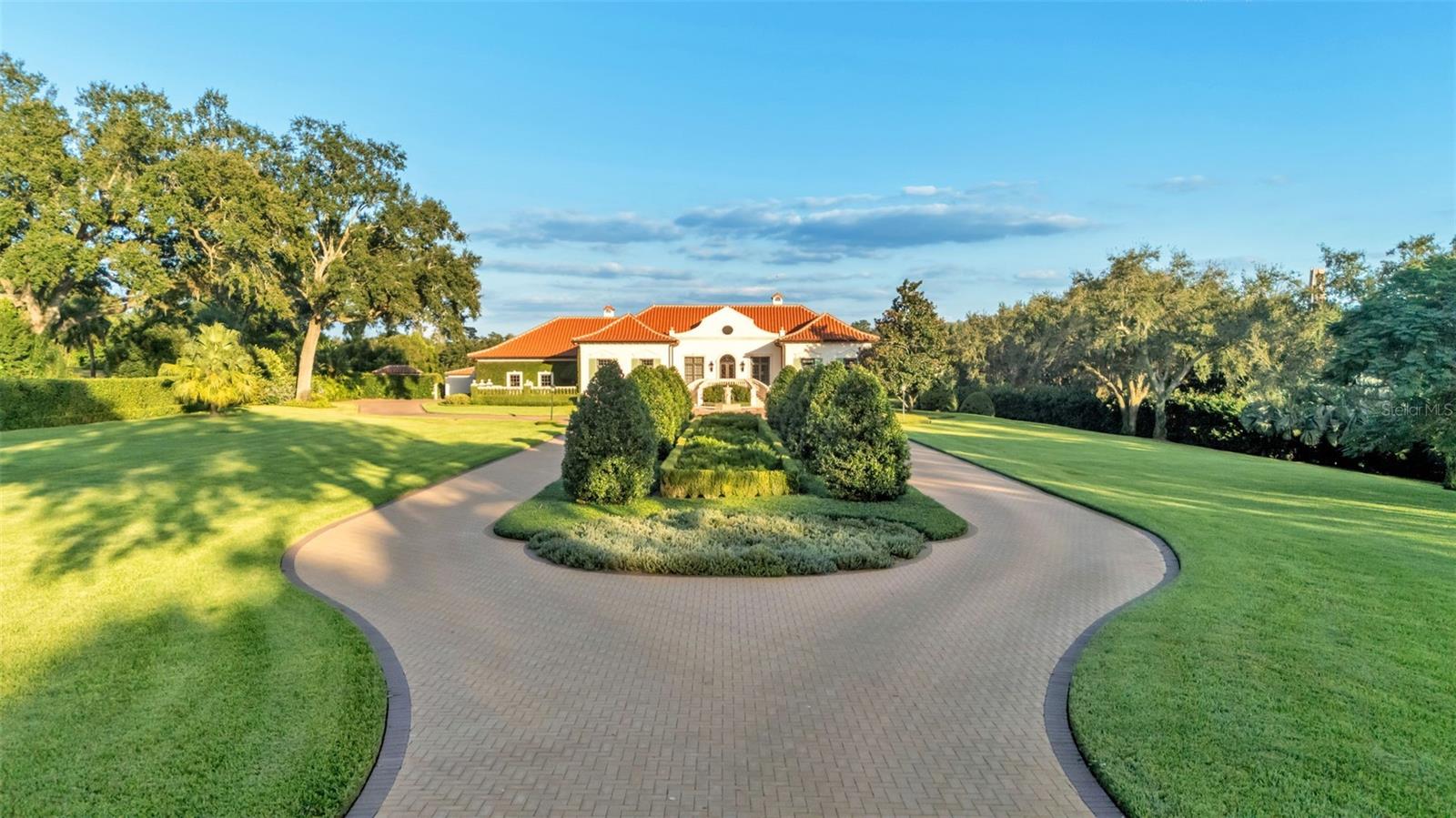 Set on 4.74 acres of meticulously landscaped grounds, this exceptional estate captures the essence of timeless elegance and modern sophistication. With sweeping views of open green spaces and the historic Bok Tower, this residence offers an unmatched combination of beauty, privacy, and grandeur.

Built in 1999, the main home spans an impressive 8,964 square feet of thoughtfully designed living space. Inside, soaring ceilings and expansive windows fill the home with natural light, creating a grand yet inviting atmosphere. Every detail has been crafted with refinement—from the well-appointed butler’s pantry to the chef’s kitchen, complete with top-of-the-line appliances, custom cabinetry, and abundant prep space ideal for entertaining or everyday living.

A private theatre, temperature-controlled wine cellar, and handsome library add to the home’s distinctive character, while ample storage throughout ensures both beauty and functionality. The seamless blend of classic architecture and modern luxury is evident in every finish and fixture.

Outdoors, the elegance continues. A resort-style pool and 1,656-square-foot pool house provide an additional haven for relaxation and gatherings, bringing the total living space to 10,620 square feet.  Surrounded by lush gardens and manicured lawns, every inch of the estate reflects a commitment to quality, craftsmanship, and design excellence.

This is more than a residence—it’s an extraordinary retreat, offering breathtaking views, refined living, and timeless appeal in one of Central Florida’s most scenic settings.