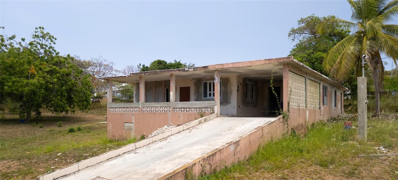 A home ready for renovation... where the next owner will enjoy the opportunity to design and personalize the space from the ground up rather than paying for someone else's choices.

Situated on nearly half an acre of titled land on a quiet street in a central Vieques location, this property offers space, character, and endless potential. The main residence features 3 bedrooms and 1 bathroom, along with an attached 1-bedroom, 1-bath accessory unit with two independent entrances—one from the carport and another from the side of the home. No doubt, it would be perfect for guests, extended family, a home office, or a future rental opportunity.

Inside, you'll find beautiful original terrazzo floors, a timeless feature of Puerto Rico architecture that adds character, durability, and a touch of nostalgia that is increasingly hard to find. The home also features a **brand-new roof sealing coat**, and **most of the windows have been replaced with brand-new windows**, providing an excellent head start for your renovation.

One of the home's standout features is its spacious covered balcony, perfectly positioned to capture the island breezes and create the kind of indoor-outdoor lifestyle that makes Vieques so special.

The property is anchored by a magnificent mature Neem tree and offers plenty of space for gardens and future improvements.

Electrical and water service are active on the property. The buyer will need to complete the utility distribution inside the residence.

This property combines location, land, character, and potential in one unique offering.

Come walk the property, stand beneath the Neem tree, feel the island breeze from the balcony, and imagine what this place could become.