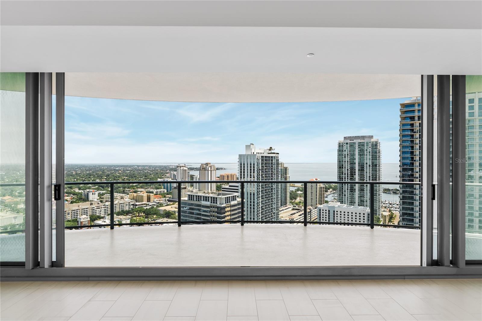 You may think you know St. Petersburg, but you've never seen her like this. You will feel like the king or queen of the city as you survey your domain from this 31st-floor residence in St. Petersburg's newest building. 

The views are nearly impossible to describe — they simply have to be experienced. As you walk in the front door, a spacious gallery opens up to the expansive main living area that looks out over the city towards Tampa Bay, with the city of Tampa in the distance. Step through the glass doors onto the wraparound terrace and the full picture comes into focus. Nearly 270 degrees of exposure puts Tampa Bay straight ahead, with Tampa's skyline rising across the water in the distance. Below you, the entire city reveals itself: Bayboro Harbor, Albert Whitted Airport, the St. Pete Municipal Marina, the base of the Pier, the Vinoy, Mirror Lake, and all the way around to the Gulf — from two different vantages at each end. Every bedroom shares a part of these views, and every bedroom opens onto this same magnificent balcony that stretches around the scope of the entire unit. There's really nothing else like it. 

Designed by award-winning Arquitectonica with interiors by New York's Celano Design Studio, the residence delivers on every expectation those views create. Ten-foot ceilings and walls of floor-to-ceiling glass carry the outdoors inside. The open great room flows into the kitchen and dining area, where European cabinetry with undercabinet lighting, quartz countertops, a six-burner gas cooktop, wine cooler, and a full JennAir appliance package meet the standard set by this price point. Grohe fixtures, a freestanding soaking tub, frameless glass shower with rain and handheld heads, and a dual-sink quartz vanity define the primary bath. Porcelain tile runs through the main living areas, each bedroom has its own en suite bath, and a powder room for guests with a spacious laundry room round out your day-to-day living. 

The building's amenities are equally serious: A 36,000-square-foot amenity deck on the seventh floor includes a resort-style heated pool, yoga lawn, state-of-the-art fitness center, Zen garden, poolside cabanas, theater lounge, private dining room, and a dedicated dog run. The Sky Lounge and Observatory on the 45th floor offer 360-degree views of Tampa Bay, the Gulf, and the city below. 

The address itself is an amenity. Central Avenue is St. Petersburg's creative spine, and 400 Central sits at the heart of it, in a block that is quickly becoming one of the city's most vibrant. Il Ritorno, one of four area restaurants to earn a Michelin Guide recommendation, is as close as across the street. The Dalí Museum, the Chihuly Collection, the Museum of Fine Arts, and the St. Pete Pier are all minutes away. From your unit high above, you'll witness the city, but walk out the front door, and you're living it.