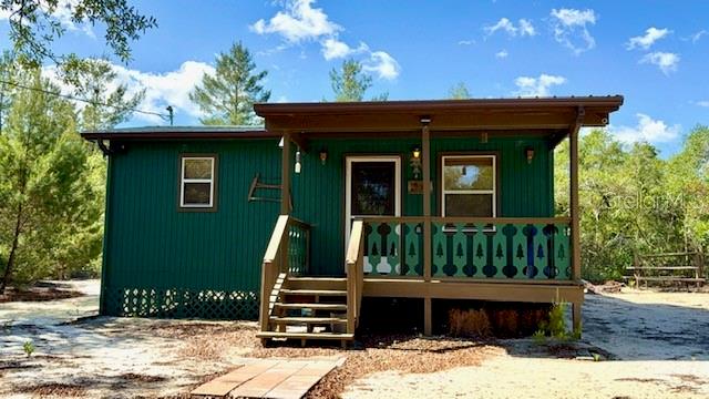 Seeking an Ocala National Forest cabin with all the creature comforts? Well here is a rare find! This cozy and well finished cabin on a fully fenced and gated double lot would be a perfect weekender or short term rental (no rental restrictions). Get away to the 430,000 acres of forest to enjoy multiple springs and lakes, hiking, wildlife watching, trail riding, and fishing. Then come back to your cabin with a fully equipped full size kitchen, enjoy your coffee on the front porch or grill out on the back porch, or just decompress in the spa worthy bathroom.