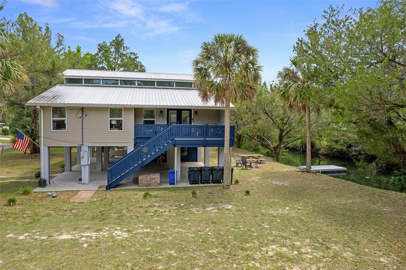 Tucked away at the end of a quiet private road, this elevated waterfront retreat captures the relaxed charm of Old Florida living while offering the flexibility today’s buyers crave. Situated on TWO CANAL-FRONT LOTS with access to the stunning Homosassa River via the Halls River, this beautifully remodeled 3-bedroom, 2-bath stilt home blends coastal comfort, investment potential, and room to grow. From the moment you arrive, the inviting Florida vacation vibe sets the tone with abundant covered parking beneath the home for vehicles, boats, trailers, golf carts, and all your waterfront toys, plus an enclosed storage area for added convenience. Climb the composite board staircase with deep blue wood railing to the inviting front porcha and double door entry. Step inside and natural light pours through dramatic transom windows stretching across both peaks of the home, creating an airy, sunlit atmosphere throughout the living spaces. A large picture window frames peaceful backyard nature views, bringing the outdoors in. The thoughtfully designed split-bedroom floor plan offers ideal owner privacy, while the spacious primary suite features a walk-in closet, jetted soaking tub, and separate shower for a spa-like retreat. The upper loft adds incredible versatility as a bonus room, game area, office, or additional sleeping space for larger gatherings and vacation guests. Outside, enjoy your floating dock with easy boating access to the river, springs, restaurants, and Gulf waters beyond. The additional unimproved corner lot offers rare flexibility—preserve it for added privacy, expand outdoor entertaining, or develop for future possibilities. With no deed restrictions, this property also presents an exceptional opportunity for personal enjoyment, seasonal escapes, or short-term rental income potential. Quiet, private, and surrounded by nature, this is the kind of waterfront property people come to Florida hoping to find.
