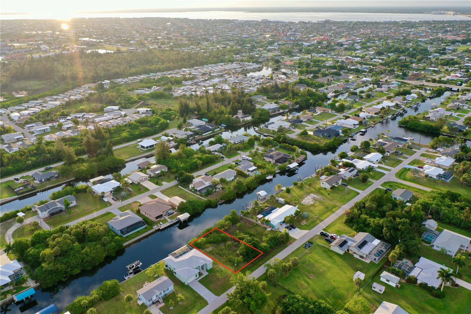 INVEST IN A DOUBLE WATERFRONT-LOT OPPORTUNITY with the adjacent parcel at 3709 Wisteria Place also available separately, allowing you to combine them for an expansive waterfront estate. BUILD YOUR FLORIDA DREAM HOME on this prime WATERFRONT lot situated on a quiet street at 3717 Wisteria Place in Punta Gorda. This highly desirable property features NO HOA and NO DEED RESTRICTIONS, giving you the ultimate freedom to design and enjoy your land. The buildable property measures 75 x 125 feet, offering a generous 9,375 square feet (0.22 acres) of land with 75 feet of road frontage and an impressive 75 feet of direct WATER-FRONTAGE. The footprint of this lot provides ample room to build a spacious custom home while leaving plenty of space to install a pool and sprawling lanai, creating your own private WATERFRONT OASIS to enjoy the sunny Florida weather. A major asset to this property is the existing WOODEN SEAWALL already in place running the full length of the lot, offering immediate shoreline stabilization for your future custom dock and boat lift.

For boaters, this location offers a smooth canal cruise of approximately 15-20 minutes, under 1 bridge (Rio Villa Bridge), out through Alligator Creek, to the open waters of CHARLOTTE HARBOR. From the harbor, you can navigate north up the Peace River, head west to the pristine sands of BOCA GRANDE, or cruise straight out to the GULF WATERS. Public water and electricity are available at the property line, requiring only a septic tank to complete your utility infrastructure. Permitting is straightforward, as county GIS maps confirm the property is completely outside of any protected SCRUB JAY habitat zones, and the National Wetlands Inventory verifies there are NO WETLANDS on site.

The surrounding location balances waterfront living with rapid access to the region's best transportation and recreational hubs. Commuting is effortless with the property located just moments from US-41, a short drive to I-75 for seamless travel north and south throughout the state, and minutes from the PUNTA GORDA AIRPORT for a quick getaway. For dining and convenience, you are just a short drive from HISTORICAL DOWNTOWN PUNTA GORDA, packed with shopping and waterfront restaurants.

Outdoor enthusiasts will love the proximity to nearby parks for hiking. You can catch stunning Florida sunsets at PONCE DE LEON PARK, or head over to GILCHRIST PARK, which features tennis and PICKLEBALL COURTS, a basketball court, and a playground. For the avid golfer, there are different CHAMPIONSHIP GOLF COURSES available for every single day of the week, all within a short drive. Baseball fans are positioned between two Major League Baseball spring training facilities, with the CHARLOTTE SPORTS PARK—home of the Tampa Bay Rays—just a short drive away, and the Atlanta Braves spring training facility in North Port equally accessible. When you want to head to the beach, the shores of BOCA GRANDE and ENGLEWOOD BEACH are both just a straightforward, scenic drive away. This exceptional waterfront lot represents a RARE OPPORTUNITY that merges ultimate building convenience with the finest aspects of Southwest Florida living.