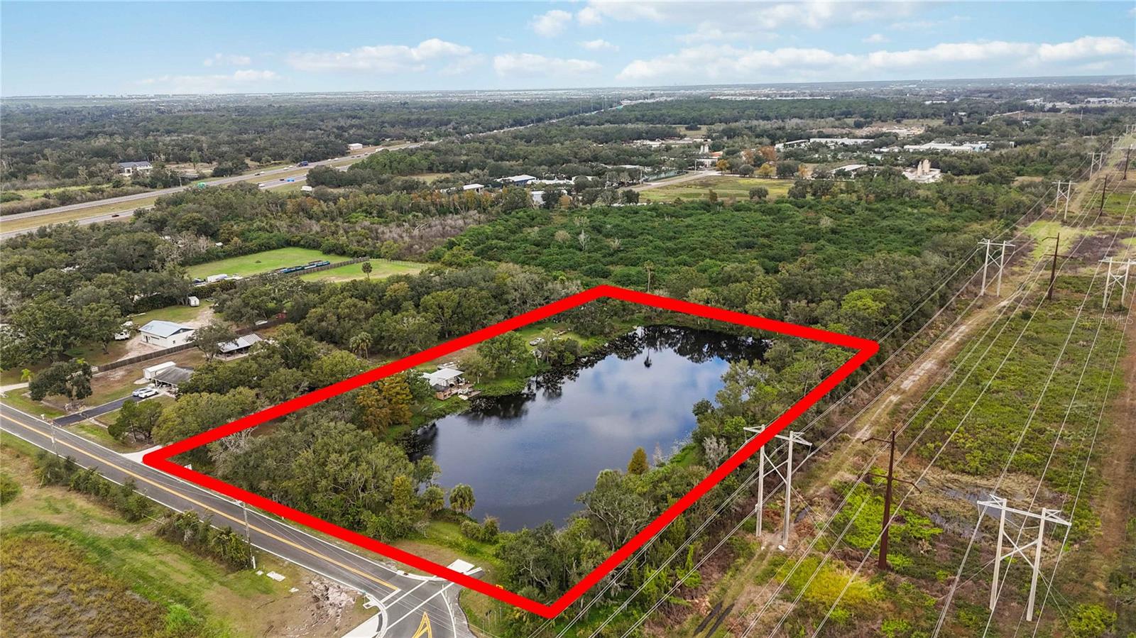 Welcome to 8011 41st Avenue East, Bradenton, FL 34211! This expansive five-acre property perfectly combines natural beauty and future potential. Nestled in the highly sought-after 34211 zip code, the property is just minutes away from I-75 and 44th Avenue East, placing it at the heart of a rapidly developing area. Currently zoned agricultural, this property offers an exceptional investment opportunity. The county's future plans for eminent domain mean that approximately half of the land—including the picturesque lake—will be acquired, ensuring a guaranteed return on investment at appraised value. This leaves roughly two and a half acres of prime, road-front land along Lena Road—set to become a major thoroughfare connecting SR 64 and SR 70—offering tremendous commercial development potential. The property includes a charming three-bedroom, two-bath home, complete with a lakefront patio and a two-car garage with a spacious workshop above. This allows for financing options, making it accessible for investors looking to hold and benefit from future growth. Additionally, there’s an opportunity to purchase an adjacent two-and-a-half-acre plot, further enhancing the property's value and development potential. In summary, 8011 41st Avenue East is more than just a property; it’s a strategic investment in a booming area, offering both immediate value and long-term gains.