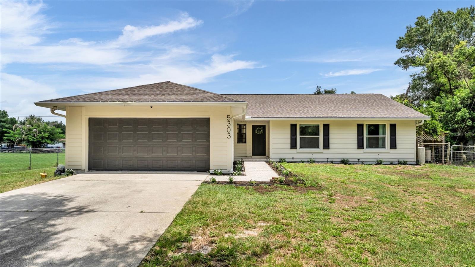Welcome to 5303 Knights Station Road, where space, privacy, and the freedom of one-acre living come together in a convenient North Lakeland location. This 4-bedroom, 2-bathroom home offers 1,747 square feet of living space, a functional split-bedroom floor plan, expansive front and back yards, a barn, and no HOA, giving you room to enjoy the property and make it your own. The home makes a fresh first impression with a newly repainted exterior, new shutters, and brand-new landscaping thoughtfully added to both the front of the home and the backyard walkout area. A spacious front yard creates a welcoming approach, while the large backyard offers plenty of room for entertaining, gardening, outdoor activities, pets, and more. Inside, the main living area is warm and inviting, featuring vaulted ceilings and a beautiful wood beam accent that adds character and architectural interest to the heart of the home. The open layout provides a natural connection between the living, dining, and kitchen spaces, making the home comfortable for both everyday living and gathering with family and friends. The kitchen features granite countertops, stainless steel appliances, ample cabinetry, and generous workspace. Several of the appliances have also been recently updated, including the refrigerator, microwave, and stove in 2024 and the dishwasher in 2026. The private primary suite is positioned separately from the additional bedrooms and includes an updated en-suite bathroom with dual sinks and a spacious walk-in shower. Three additional bedrooms provide flexibility for family, guests, a home office, playroom, fitness space, or hobbies. Step outside and enjoy the space that a full acre provides. The expansive backyard offers endless possibilities, while the play set will remain with the sale of the home, allowing the outdoor space to be enjoyed from day one. Toward the back of the property, an existing barn provides additional flexibility and potential. Upgrade or customize it to fit your needs whether you envision additional storage, a workshop, hobby space, equipment storage, or another use that complements your lifestyle. Additional property highlights include a roof replaced in 2020, a brand-new water heater in 2026, septic service completed in 2024, and well water with Culligan service. With a full acre, four bedrooms, spacious outdoor areas, a barn, meaningful updates, and no HOA, this North Lakeland property offers the space and versatility that can be difficult to find. Conveniently located near shopping, dining, and major roadways, 5303 Knights Station Road offers room to spread out without giving up everyday accessibility. This property may be eligible for USDA financing, offering qualified buyers the opportunity for 100% financing with no down payment required. Buyers are encouraged to consult with their lender to confirm individual borrower and property eligibility. Schedule your showing today!