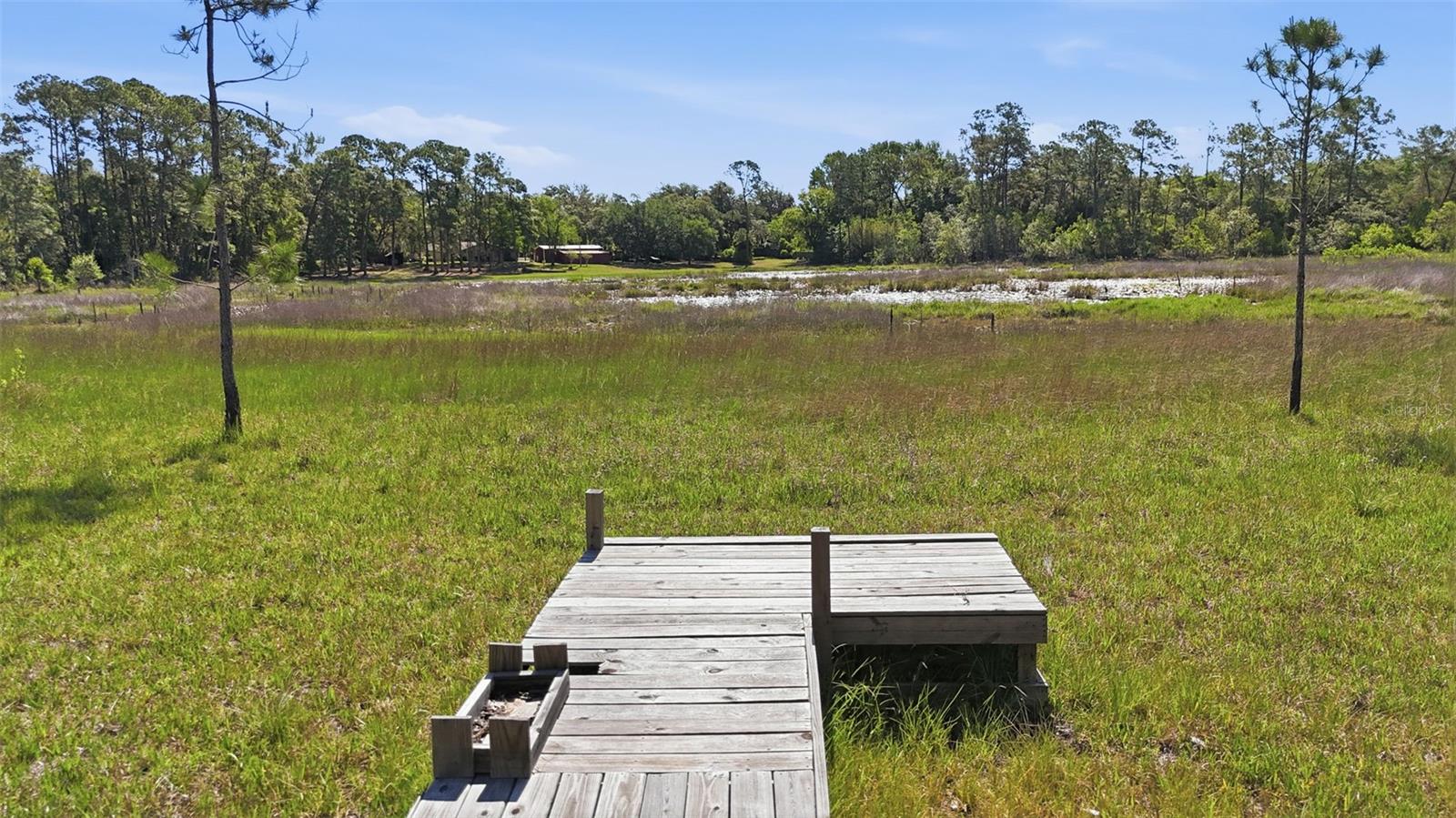 RARE FIND! This unique property located in NE Eustis represents a versatile opportunity, particularly given that the foundational infrastructure like the 240-foot deep well and electricity is already established. With nearly five acres of land and a zoning designation that allows for two dwellings, you have the rare flexibility to construct a primary stilt home, tiny home or manufactured home (block construction is possible but may require additional due diligence) while maintaining the option for a secondary ADU or pole barn. The gradual slope of the terrain toward the water is a natural fit for stilt construction, as it provides the necessary elevation for both flood mitigation and unobstructed views of the lake. Positioned on a quiet dead end dirt and gravel road, your oasis should capture lake breezes and possibly utilize the slope for under-house parking or storage.

The recent survey from April 2025 is a critical asset for your planning process, as it clearly defines the wetland and septic setbacks that will dictate exactly where your footprint can sit. Because the driest portion of the lot is near the front street, you might find that placing the home in this area saves on utility trenching costs while still allowing the back of the property to serve as a private waterfront escape. The lack of an HOA combined with the General Agricultural zoning means your plans for beekeeping or small-scale livestock can be integrated seamlessly into the landscape without restrictive oversight. 

No timeframe to build and NO HOA. Since the property is partially cleared, the transition from a vacant lot to a functional homestead is significantly more straightforward than starting with raw, untouched land. The partially cleared sections are perfect for the General Agriculture allowance (bees, goats, cows, horses, chickens, or gardens). All information deemed accurate but should be independently verified. Located within 10 minutes of shopping plaza and 20 minutes to Downtown Mount Dora.