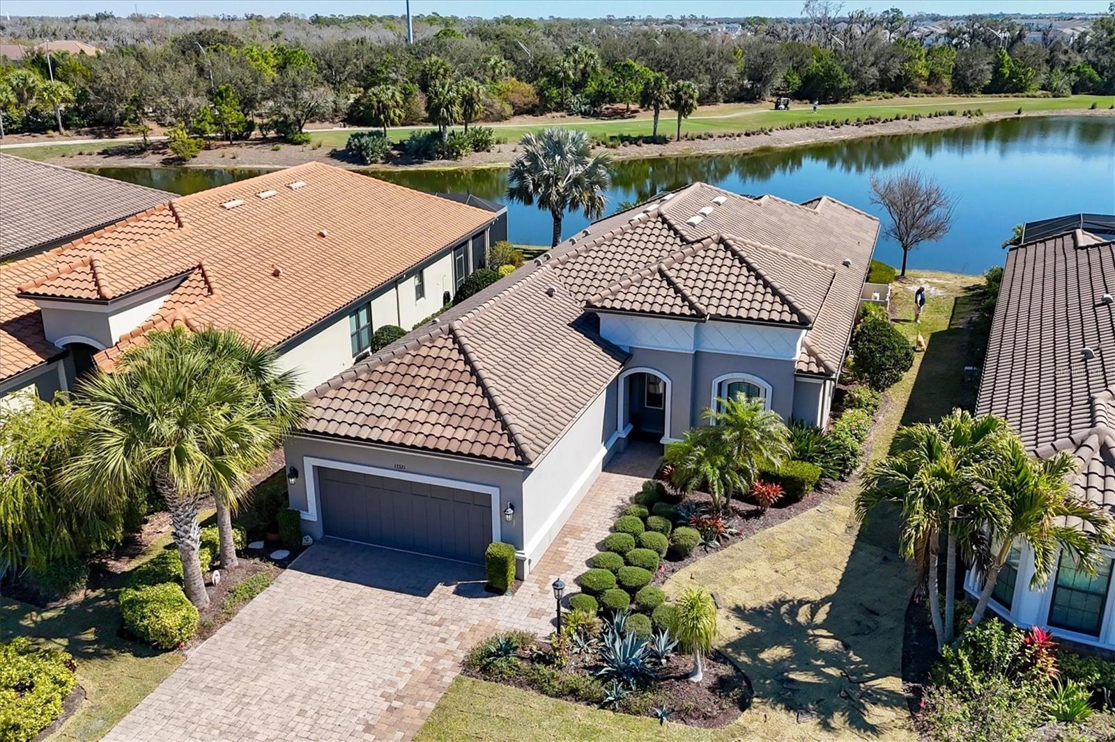 Welcome to 13321 Sorrento Way in  the highly sought after Esplanade Golf and Country Club of Lakewood Ranch, one of the premier resort style communities in Lakewood Ranch. This exceptional home with deeded Golf Membership included, offers the ultimate Florida lifestyle, featuring breathtaking lakefront and golf course views of the 14th hole, and a spectacular outdoor living space designed for both relaxation and entertaining. Step outside to your private oasis, where a sparkling pool is framed by a panoramic screen enclosure that maximizes the stunning water and fairway vistas. The expansive lanai showcases a gorgeous outdoor kitchen and a cozy fireplace, roll down hurricane screens, the perfect setting for al fresco dining, sunset cocktails, or hosting unforgettable gatherings year round. Inside, the chef's kitchen is both stylish and functional, appointed with quartz countertops, stainless steel appliances, a spacious pantry, and an eat-in kitchenette overlooking the view. A large center island with bar seating provides ample prep space and serves as the heart of the home for casual meals and entertaining. The Owner's Suite features walk-in closet space, and an en-suite bathroom with walk in shower and dual vanities. This popular Farnese Model features an open floor plan with an additional guest bedroom and bath, perfect for out of town guests, along with a large den offering private space for home office options. Living in Esplanade means enjoying a truly all inclusive lifestyle. Community amenities include a championship golf course, two clubhouses, two resort style pools, tennis and pickleball courts, bocce ball, fitness center, full service spa, dog parks, walking trails, and vibrant clubs with dining and social events, all designed to make every day feel like a vacation. This home combines luxury, comfort, and unparalleled scenery in one of the area's most desirable communitites. Experience the perfect blend of elegant indoor living, and spectacular outdoor enjoyment!