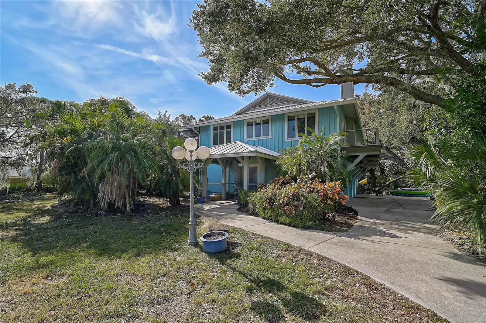 Private Key West–style retreat on 2.53 wooded acres in Osprey. Rarely does a property of this size become available in such a convenient location—just minutes from Pine View School, shopping, restaurants, and the Intracoastal Waterway—yet offering the privacy and space of a true country setting. This combination of acreage and accessibility makes the home exceptionally unique for the area. A generous 37x60 paver-brick patio surrounds the screened lap-style pool, now protected by a freshly updated pool cage. Multiple French doors open to wide second-floor decks overlooking the peaceful wooded backdrop. A recently added metal roof enhances durability, longevity, and value. Inside, the home features oak hardwood floors, vaulted tongue-and-groove cypress ceilings, and a striking wood-burning fireplace that add warmth and character throughout. The kitchen and baths retain their classic charm and present an excellent opportunity for updating to suit modern preferences. The flexible layout includes two potential primary suites and a first-floor bonus room with full bath that works well for guests or creative uses. The lower level remains plumbed for a second kitchen and laundry, offering an easy path for future installation or multigenerational living. With no deed restrictions and an expansive amount of usable land, this country estate in town offers endless potential—whether for hobbies, animals, enhancements, or simply enjoying the quiet beauty of its natural surroundings.