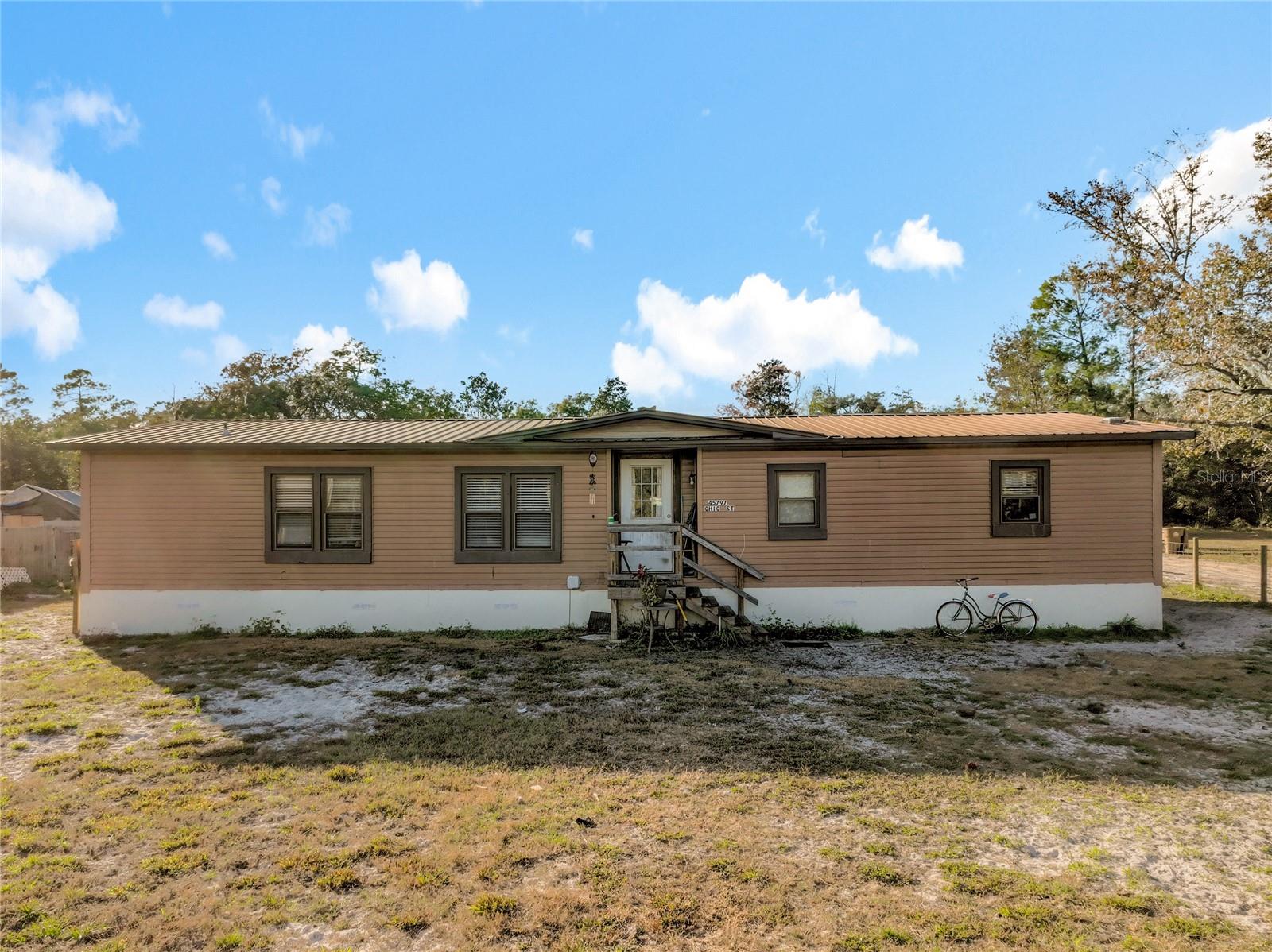 Welcome to 45797 Ohio Street, Paisley, FL, offering the best of rural country living in Lake County. This property is set on a spacious lot with mature trees, providing privacy and a peaceful setting with no HOA. Enjoy a relaxed Florida lifestyle surrounded by nature while still being conveniently located near nearby towns and amenities.  Situated minutes from local lakes, natural springs, and the Ocala National Forest, this property is ideal for outdoor enthusiasts, with easy access to boating, fishing, hiking, and wildlife. The generous acreage/lot size offers plenty of room for outdoor living, gardening, or future improvements.  Amazing Fireplace, built in China cabinets, above ground pool, large carport and much more!  Well and Septic are newer.  Perfect for a primary residence, first-time buyer, second home, vacation getaway, or investment property, this location combines tranquility with accessibility. A great opportunity to invest in a property in a growing area known for its natural beauty and recreational opportunities.