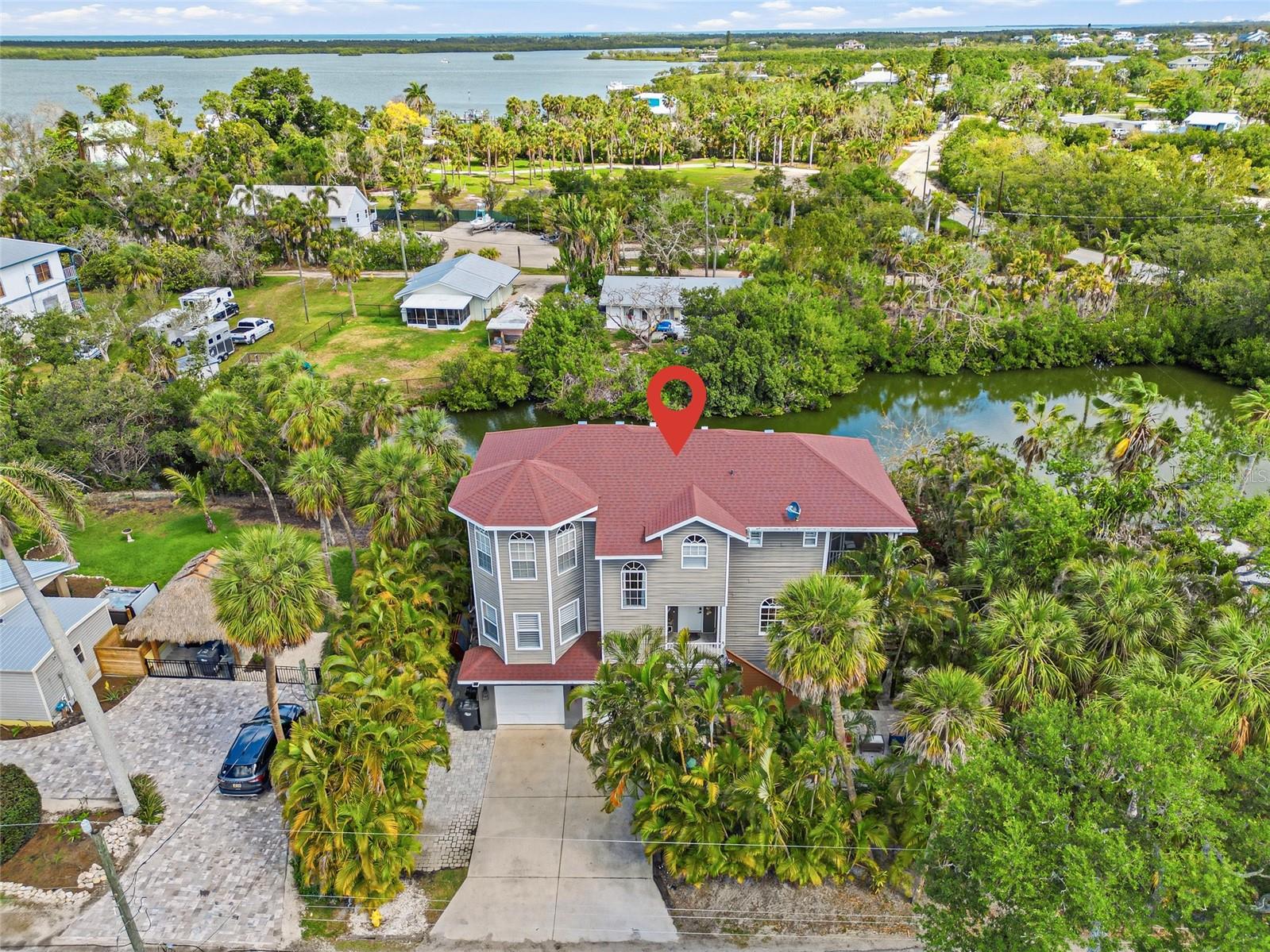 Welcome home to a peaceful retreat nestled in the heart of Terra Ceia, where natural beauty surrounds you at every turn. As you wind through the community, you’ll immediately feel a sense of calm before arriving at this stunning residence, framed by lush tropical landscaping and captivating curb appeal.  Access is effortless with both elevator and stair entry leading to the main living level as well as the 3rd floor. Inside, rich wood flooring flows seamlessly throughout, setting a warm and inviting tone. The expansive living room is ideal for entertaining or unwinding, showcasing tranquil views of the shimmering saltwater lake and opening to a private balcony perfect for enjoying gentle breezes and serene sunsets. A versatile study or den just off the living area provides the ideal space for a home office or quiet retreat.  The kitchen is designed to inspire, offering abundant cabinetry and countertop space to satisfy any home chef. A second private balcony makes outdoor grilling both convenient and enjoyable. The adjoining formal dining room is perfectly suited for hosting gatherings, while a well-placed half bath completes this level.  Upstairs, the third floor features a full-size laundry room and a spacious primary suite that serves as a true sanctuary. Enjoy your own private balcony, a generous walk-in closet, and a beautifully appointed ensuite bath. Two additional bedrooms are thoughtfully positioned down the hall, sharing a full bathroom and a private balcony with picturesque lake views.  Step outside and immerse yourself in the tranquil surroundings. Your private dock invites you to relax by the water or enjoy peaceful moments lakeside. An oversized swim spa offers the perfect place to unwind after a long day, while multiple seating areas throughout the grounds create inviting spaces for conversation or quiet reflection.  The expansive garage provides ample room for vehicles, storage, or even a workshop tailored to fit your lifestyle needs. For those seeking direct access to Gulf waters and exceptional fishing, a rare opportunity awaits. The vacant lot across the street is available for purchase at $175,000, offering a newly installed dock and additional space for parking or entertaining.  This is more than a home, it’s a serene escape in one of Terra Ceia’s most peaceful settings. Don’t miss your opportunity to own your own slice of paradise. Schedule your private showing today.  Click Tour 2 For Matterport Tour.