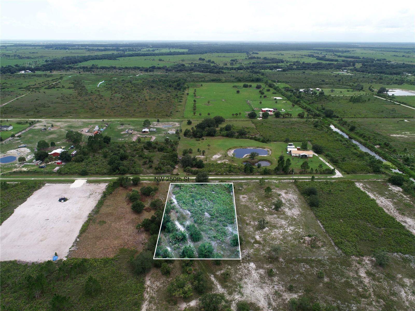 Discover the opportunity to create your own private retreat at 18235 NW 250th Street in Okeechobee, Florida. Situated on 1.25 acres, this property offers a rare combination of freedom, flexibility, and long term potential in a growing area of Florida. With no HOA and located outside of a flood zone, you have the ability to design and build with confidence and fewer restrictions, whether your vision includes a manufactured home, modular residence, or a custom single family estate. Electricity is available, and according to the Florida Wetland Mapper, the property is free of wetlands, providing a strong foundation for future development.

This location offers the space and privacy many buyers are seeking, while still maintaining convenient access to everyday essentials and lifestyle amenities. Nearby schools include Seminole Elementary School, Yearling Middle School, and Okeechobee High School, providing options for families looking to establish roots in the area. Grocery shopping and daily conveniences are just a short drive away with Publix Super Market at Town Commons, Walmart Supercenter, and local markets serving the community.

For those who value an active outdoor lifestyle, this property is ideally positioned near some of Florida’s most sought after natural attractions. Lake Okeechobee, one of the largest freshwater lakes in the country, is just minutes away and offers world class fishing, boating, and waterfront recreation. Scott Driver Park provides boat ramps, picnic areas, and access to the water, while nearby Kissimmee Prairie Preserve State Park offers expansive open land, wildlife viewing, hiking, and one of the darkest night skies in Florida for stargazing. Pet owners will appreciate nearby dog friendly parks and open green spaces throughout the area.

The property also provides accessibility to key Florida destinations, making it an ideal balance between privacy and connectivity. Okeechobee’s downtown area is within easy reach, while larger cities such as Port St. Lucie, Fort Pierce, and West Palm Beach are all accessible for expanded dining, shopping, and entertainment. For travel, Palm Beach International Airport is approximately an hour and a half away, with additional access through Treasure Coast International Airport and Orlando International Airport for both domestic and international travel.

Whether you are looking to build a primary residence, a weekend retreat, or secure land as a long term investment, this property presents a compelling opportunity to create something meaningful in a location that continues to gain attention for its space, lifestyle, and growth potential.