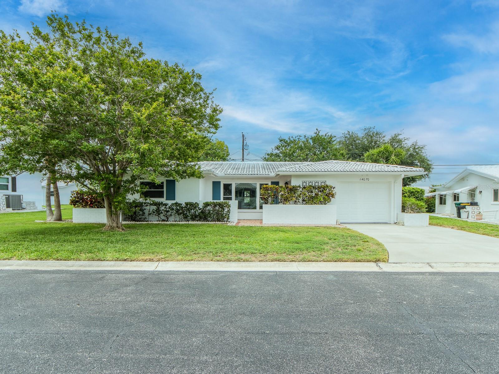 This is a beautiful home surrounded by mature landscaping. The front door opens into a large open floor plan that is flooded with sunlight from the large front impact windows. The flooring, new LVP, flows throughout, bringing continuity to the home. The kitchen has a new refrigerator and range. A pass-through window makes entertaining easy. The breakfast room adds space for those who would like to expand the kitchen. A wonderful inside laundry room is just off the breakfast room and connects to the garage. Both bedrooms are large. One with built-in closets and the primary with a large walk-in closet. The paver patio is off the Florida room. The backyard offers shade and room to add another patio should you choose. The driveway has been widened to easily accommodate two vehicles. The monthly maintenance fee of $251.20 includes water, sewer, trash, lawn mowing, a clubhouse with a full calendar of activities and a heated pool. The homes are painted every 8-9 years, and roofs are pressure cleaned every 8-9 years. Five minutes to the Gulf beaches, shopping and restaurants. The home is 40 minutes from Tampa International Airport.
