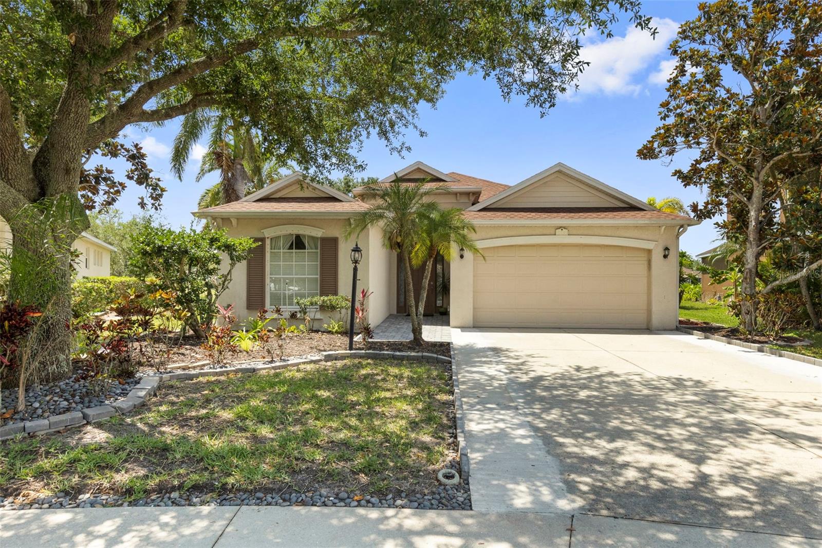 One or more photo(s) has been virtually staged. Tucked away on a quiet cul-de-sac in the premier gated community of University Place in Bradenton, this Bruce Williams Newport II offers the perfect blend of comfort, style, and peaceful waterfront living. Featuring two bedrooms, and a den or third bedroom, two bathrooms, a two-car garage, and 1,990 square feet of thoughtfully designed living space, this home captures beautiful views of a spring-fed pond from some of its most inviting spaces.

Approaching the home, lush Florida-friendly mature landscaping creates a warm and inviting first impression. Inside, natural light pours through the home, highlighting updated tile flooring, soaring vaulted ceilings, and an open floor plan designed for both everyday living and entertaining.

At the heart of the home, the spacious kitchen is beautifully appointed with recessed lighting, 42-inch upper maple cabinetry, updated backsplash, Corian countertops, stainless steel appliances currently electric, natural gas is available should you prefer a gas range, an island bar with seating, a built-in workspace, and abundant storage throughout. Perfectly positioned to overlook the outdoor living space and tranquil pond views, the kitchen flows effortlessly into the main living area.

The living room offers sliding glass door access to the covered and screened lanai, creating seamless indoor-outdoor living. Just adjacent, the great room provides additional flexible gathering space ideal for relaxing, entertaining guests, or creating a cozy sitting area centered around the scenic backyard views.

The owner’s retreat is privately situated and designed for comfort, featuring direct access to the lanai, peaceful pond views, and dual walk-in closets. The en-suite bath includes a dual sink vanity, glass walk-in shower, soaking tub, and ample space for a true spa-like experience.

Bedroom two is generously sized and conveniently located near the second full bathroom, offering privacy and comfort for guests or family. The bonus room/den on this side of the home provides the perfect space for a home office, library, or flex room to fit your lifestyle. The laundry room adds everyday convenience and features a utility sink for added functionality.

Step outside to your private outdoor retreat where the covered and screened lanai with expansive pavers creates the ideal setting for morning coffee, evening dining alfresco, or simply enjoying the peaceful waterfront backdrop. The paver patio extends beyond the lanai, leading to breathtaking views of the spring-fed pond accented by three lighted fountains that create a truly serene atmosphere.

Notable updates include Roof (2024), HVAC (2025), and Gas Water Heater (2023), providing peace of mind for years to come. Low HOA fees include access to exceptional community amenities such as two resort-style heated pools, a heated spa, two poolside outdoor kitchens, a fitness center, nature trails, and a playground.

Perfectly positioned near The Mall at University Town Center, Nathan Benderson Park, Whole Foods Market, The Fresh Market, and endless shopping and dining destinations, this location also offers convenient access to I-75 and is just a short drive to downtown Sarasota, downtown Bradenton, St. Armands Circle, Lido Key, Longboat Key, and the world-renowned shores of Siesta Key Beach. For a virtual tour, click the provided link and experience the beauty of this remarkable property.