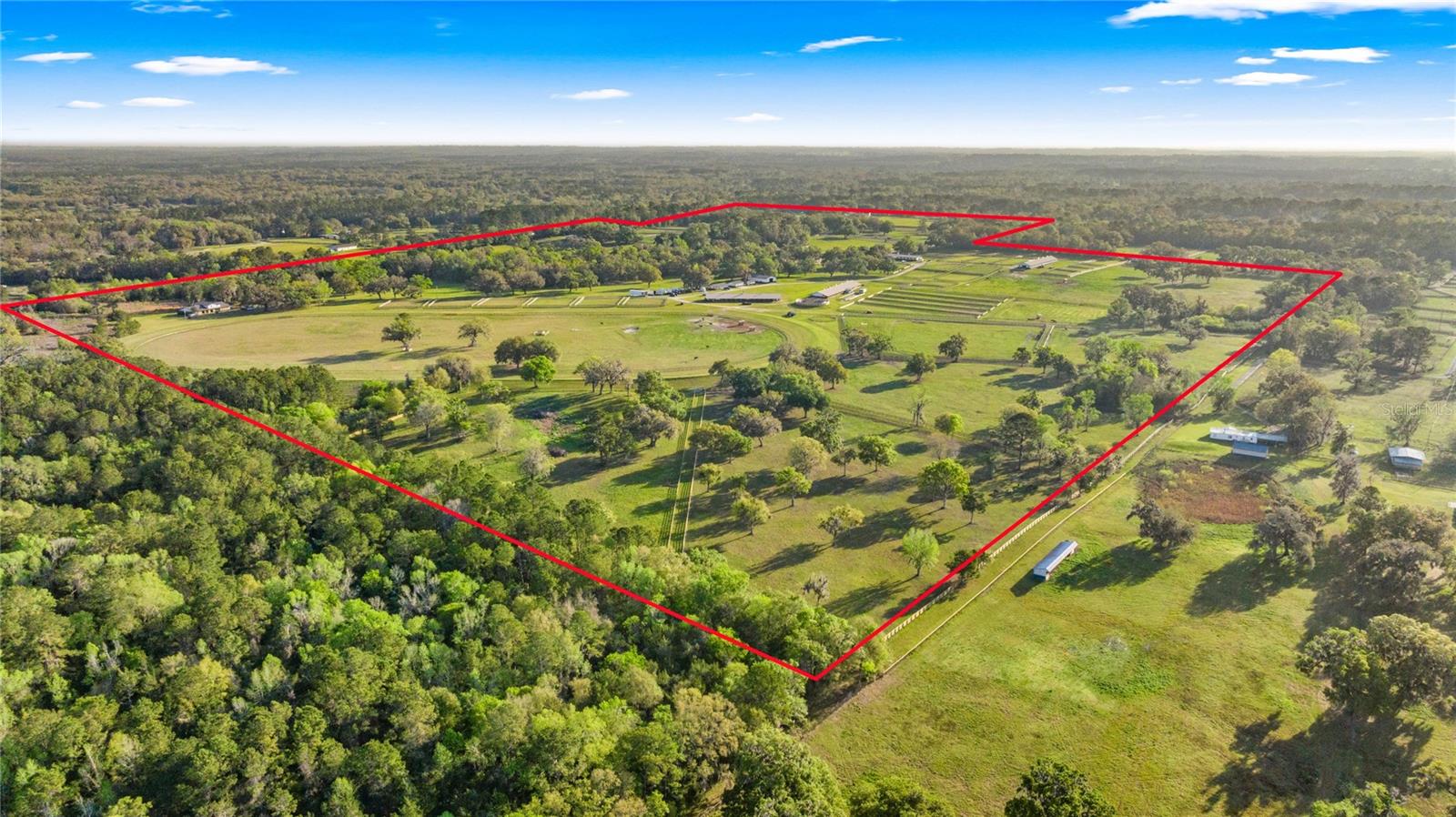 Discover a sprawling 194-acre equestrian paradise, 4 miles to HITS and just under 10 miles to WEC. This impressive setup boasts seven barns with over 130 stalls, a 7 bedroom house, a 2 bedroom log cabin, a 2 bedroom house with a pool, a renovated 4 bedroom staff quarters and multiple other cozy barn apartments. Horses will thrive with 20 meticulously cross-board fenced paddocks, a speedy 5/8-mile track, a state-of-the-art horse walker, and a refreshing equine pool. The property also boasts brand new metal roofs on the barns as well as a large, irrigated sand jumping arena. Toss in 9 RV hookups, and you’ve got a versatile haven ready for trainers, riders, and dreamers alike.  All Buyers should independently verify all information provided regarding this Property. The Sellers, Realtor and Broker make no representation as to the accuracy of this information. All Buyers should perform their own independent due diligence regarding this Property before executing a Contract for Sale and Purchase for this Property.