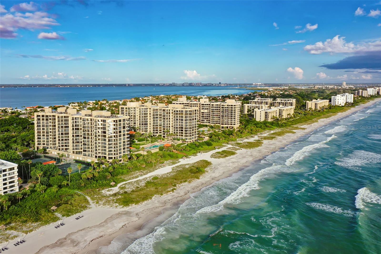 Under contract-accepting backup offers. Welcome to an extraordinary corner residence at The Water Club where timeless elegance meets effortless coastal living on Longboat Key. Offering 3,275 square feet of beautifully designed interior space, this 3-bedroom, 4.5-bath condominium captures sweeping unobstructed expansive views of the Gulf of Mexico, glowing sunsets, Sarasota Bay, and the city skyline from nearly every room. Floor-to-ceiling windows and expansive sightlines fill the home with natural light, creating a serene and sophisticated atmosphere throughout. Designed with refined craftsmanship, the residence showcases custom woodworking, hardwood floors, and soaring 10-foot ceilings that enhance the sense of scale and luxury. The thoughtfully designed layout provides generous living and entertaining spaces while maintaining privacy for guests. The home is in true move-in condition and has been thoughtfully updated with all-new appliances in 2025, blending modern convenience with classic finishes. Enjoy the exclusivity of private elevator access directly to the residence, along with full concierge services that elevate everyday living. The building offers an impressive collection of resort-style amenities, including a Gulf-front swimming pool overlooking pristine white sand beaches, a fully equipped fitness studio, an elegant library, a grand ballroom for entertaining, and a game room for relaxation and recreation, a premier parking space, and as well as climate controlled storage units. This exceptional property delivers the best of beachfront living with luxury, privacy, and breathtaking views all within one of Longboat Key’s most desirable addresses. A rare opportunity to own a refined coastal retreat where every detail has been carefully considered and every day feels like a getaway.
