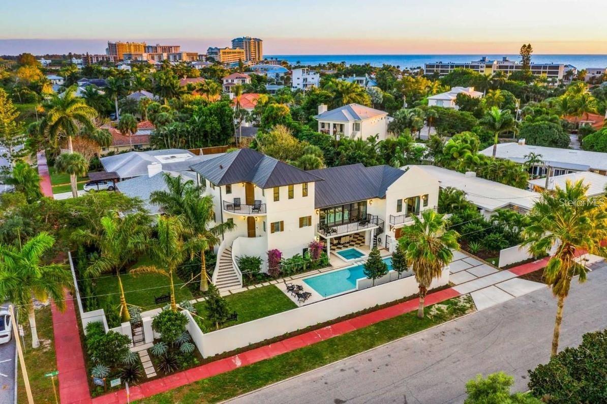 STUNNING ESTATE ON LIDO KEY!!! WELCOME TO YOUR COASTAL DREAM HOME!!! This 6 bedroom 5 1/2 bath property is TURNKEY FURNISHED, has an ELEVATOR to all levels, and boasts vaulted ceilings. The owner spared no expense when building this home. High end designer finishes and attention to detail are evident throughout. The master bedroom is a tranquil oasis and offers a private balcony providing breathtaking views. You will also find a large walk in closet and an oversized bathroom featuring double vanities, free standing bath tub, and a walk in shower. The additional four bedrooms are all en-suite and are laid out perfectly. The chef's kitchen has high end wood cabinets, quartz countertops, stainless steel appliances and a large center island. The great room floor plan is expansive and features high ceilings with wood beams. Step into your outdoor oasis with a private heated pool with a sun shelf, perfect for both kids and adults to soak up the Florida sun. A covered spa ensures year-round enjoyment. The expansive covered patio extends nearly the entire space beneath the home, ample bar-top seating, dining, TVs, and gaming areas, including a pool table and foosball. Convenience is key as you're just a short stroll to Lido Key Beach and or to St. Armand's Circle with wonderful shops and restaurants. With a 2-car garage and space for up to four cars in the driveway, you have ample parking options. This is the ultimate vacation home for you and your family. Currently a successful vacation rental with forward bookings in place.