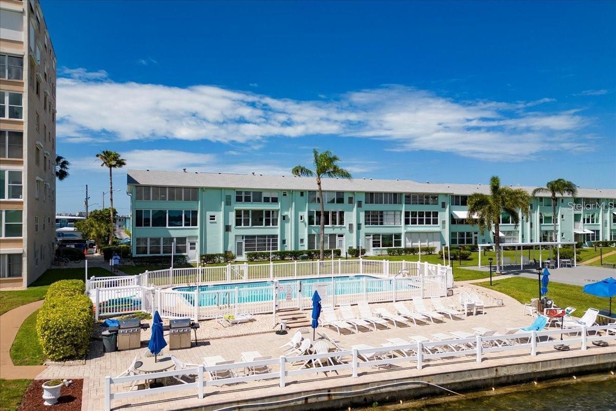 One or more photo(s) was virtually staged. Enjoy waterfront views from this beautifully updated 2 bedroom 1 bath condo in the desirable Shore View community, centrally located in South Pasadena. This first-floor waterfront unit features an open living and dining area, a renovated kitchen and bathroom with new quartz countertops, and a bright Florida room overlooking Boca Ciega Bay with direct access to the courtyard and pool—an ideal space for relaxing or entertaining. Additional recent updates include luxury vinyl plank flooring, newer windows, electrical panel and updated wiring throughout. Shore View is a well-maintained 55+ community offering two heated pools, a clubhouse, fitness center, shuffleboard/cornhole courts, billiards and ping-pong tables. The unit includes assigned parking space #32, convenient guest parking, a dedicated storage shelf in the first-floor storage room, and laundry facilities on every floor.  Ideally located just minutes from St. Pete Beach, waterfront dining, shopping, parks, and vibrant downtown St. Petersburg, this move-in-ready condo offers the perfect blend of waterfront living, convenience, and low-maintenance Florida lifestyle. Make an appointment today!