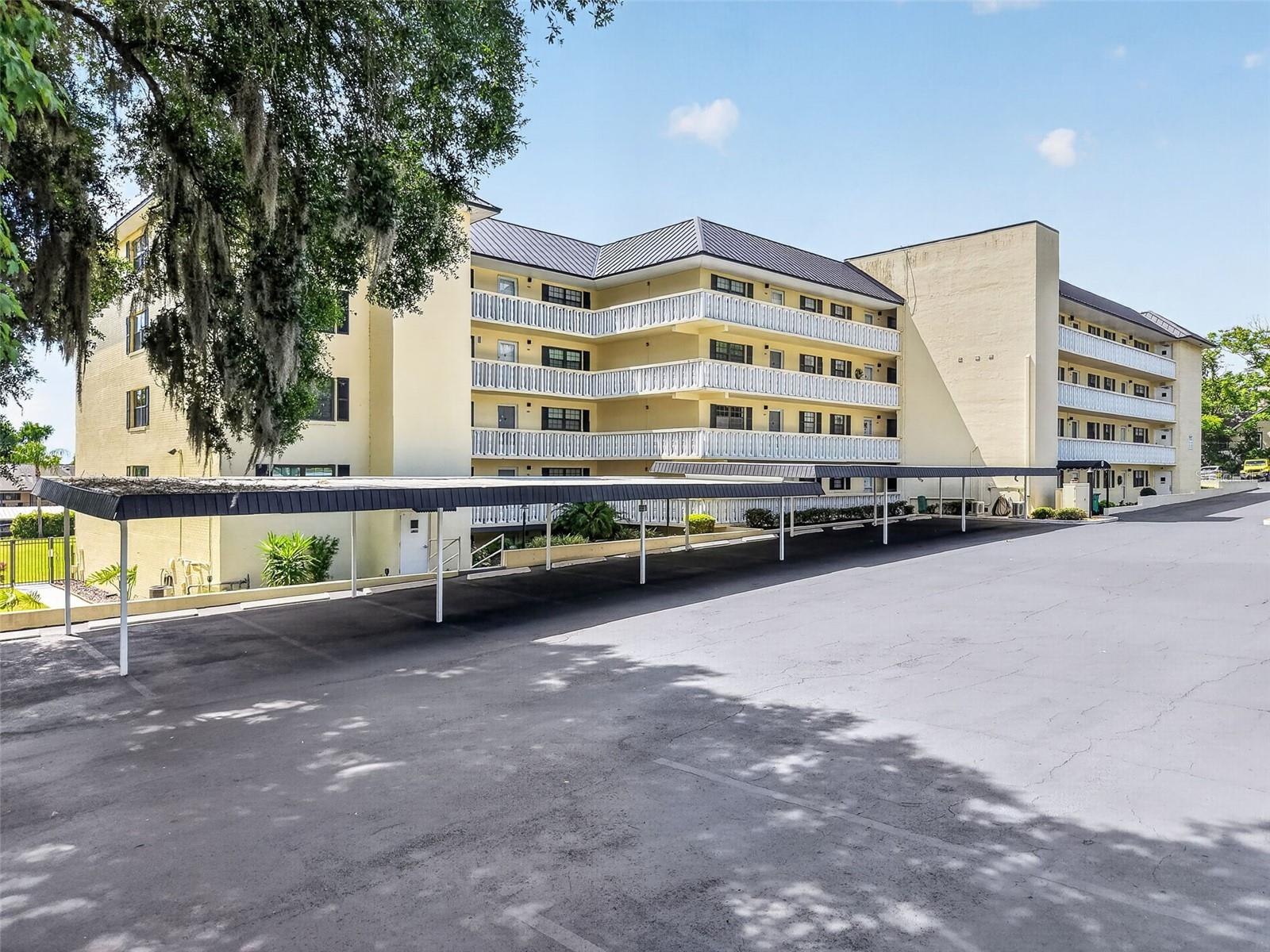 Perfectly positioned just moments from the heart of Historic downtown Mount Dora, this completely renovated garden-style condo offers a rare blend of luxury, privacy, and modern convenience. Completed in January 2025, Unit 1 is the only residence in the community with direct walkout access to the pool and grilling area, creating an effortless indoor-outdoor lifestyle while also enjoying the privacy of having no adjacent neighbors. Southern Oaks is a well-maintained, 55+ community offering a relaxed lifestyle with great amenities — including a heated pool, shuffleboard courts, clubhouse, workshop, designated storage, two community laundry rooms, and elevators — all surrounded by tranquil, landscaped grounds. Inside, the expanded kitchen was thoughtfully redesigned with timeless white Shaker cabinetry featuring soft-close doors and drawers, quartz countertops, striking Zellige tile backsplash, and abundant storage including large pot and dish drawers and a built-in pantry with rollout shelving. A full suite of Samsung SmartThings™ stainless steel appliances elevates the space with smart technology, including a counter-depth refrigerator with dual icemakers, internal auto-fill water pitcher, induction range with air fry convection oven, and app-controlled functionality. A built-in 30-inch wine and beverage center completes the kitchen’s sophisticated design.
The open living and dining areas are accented by custom beamed ceilings, recessed lighting, smooth-finish ceilings throughout, and polished concrete floors that create a clean, contemporary aesthetic. Every detail has been carefully curated, from the solid-core doors and oversized 5½-inch baseboards to the custom trim work and top-down/bottom-up shades throughout the home.
Both bedrooms enjoy ensuite-style bath access, including a beautifully redesigned guest bath with a walk-in tiled shower featuring rainfall, body spray, and handheld fixtures behind custom glass doors. The expanded primary suite offers a true spa-like retreat with a luxurious walk-in shower featuring rainfall, waterfall, body spray, handheld fixtures, and integrated Bluetooth™ speaker system, along with a floating double vanity illuminated by subtle low-voltage lighting. Raised ceiling details and a stylish fandelier enhance the primary bedroom, while custom Elfa™ closet systems maximize storage throughout the home.
Additional upgrades include dual hot water heaters, a whole-house dual water filtration system, whisper-quiet humidity-sensing bath fans vented to the exterior, new storm doors at the entry and screened lanai, and recessed lighting throughout key living spaces. This exceptional condo combines thoughtful design, high-end finishes, and an unbeatable location near the shops, restaurants, waterfront, and charm of downtown Mount Dora. This condo is perfect as a full-time residence, seasonal retreat, or investment property, delivering the best of Mount Dora’s friendly community and vibrant lifestyle.
