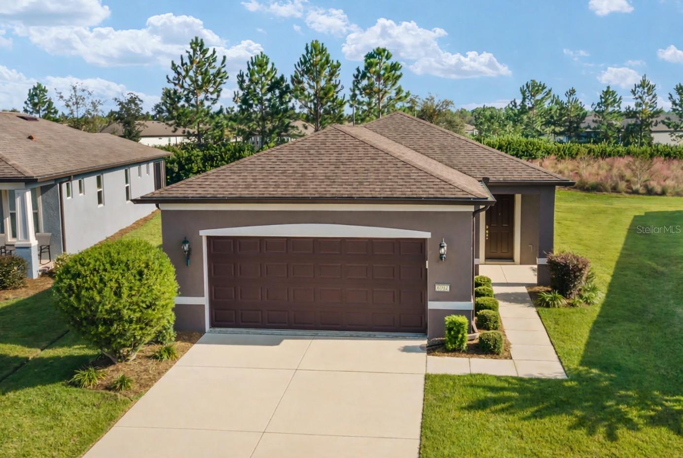 Carefree living awaits in this impeccably cared for 3-bedroom, 2-bath Crestview model, perfectly positioned on a premium lot overlooking a scenic nature berm within the gated 55+ Stone Creek Golf Course Community. Thoughtfully expanded with an extended garage and lanai, this home offers the extra space you want for hobbies, guests, and relaxed outdoor living, all surrounded by resort-style amenities designed to enrich your everyday life. A welcoming entry foyer opens to a light-filled, open-concept living area enhanced by 2-panel Cheyenne-style doors, 2" faux wood blinds, and an added bedroom that provides ideal flexibility for guests or a dedicated hobby room. Entertaining flows effortlessly with the connected Living and Dining spaces, featuring a soothing neutral palette, transom windows that bring in beautiful natural light, and easy-care tile flooring. Expansive glass sliders open to the screened and extended lanai outfitted with custom Coolaroo sunshades and recessed lighting, creating a private retreat overlooking a landscaped nature berm with no neighbors directly behind. The well-appointed kitchen shines with stainless steel appliances, quartz countertops, a glass-tile accented backsplash, a spot-resistant Moen faucet, and a large island with bar-height seating. An added buffet area offers even more prep and storage space. The Owner’s Suite features a triple window for abundant natural light, along with an ensuite bath offering a step-in shower, a spacious double-sink vanity, and a generous walk-in closet. Additional upgrades include a SECO-installed surge mitigator, pre-plumbing for a home water softener, pull-down attic stairs in the garage, upgraded bath fixtures, and an updated laundry room. Best of all, irrigation and lawn care are expertly managed for you, giving you more time to embrace the exceptional lifestyle of this vibrant community, featuring a 24/7 staffed gated entrance for security and peace of mind. Luxury-inspired amenities include heated pools, a state-of-the-art fitness center, a spa, and relaxing hot tubs and saunas. Stay active with pickleball, bocce, tennis, and a softball field, while a dedicated lifestyle staff curates entertainment, activities, and special events to foster connections. Just beyond the gates, enjoy a golf course, pro shop, and restaurant, perfect for socializing and unwinding. Whether you’re relaxing at home or embracing the vibrant lifestyle just outside your door, this is the easy, elevated living you’ve been waiting for.