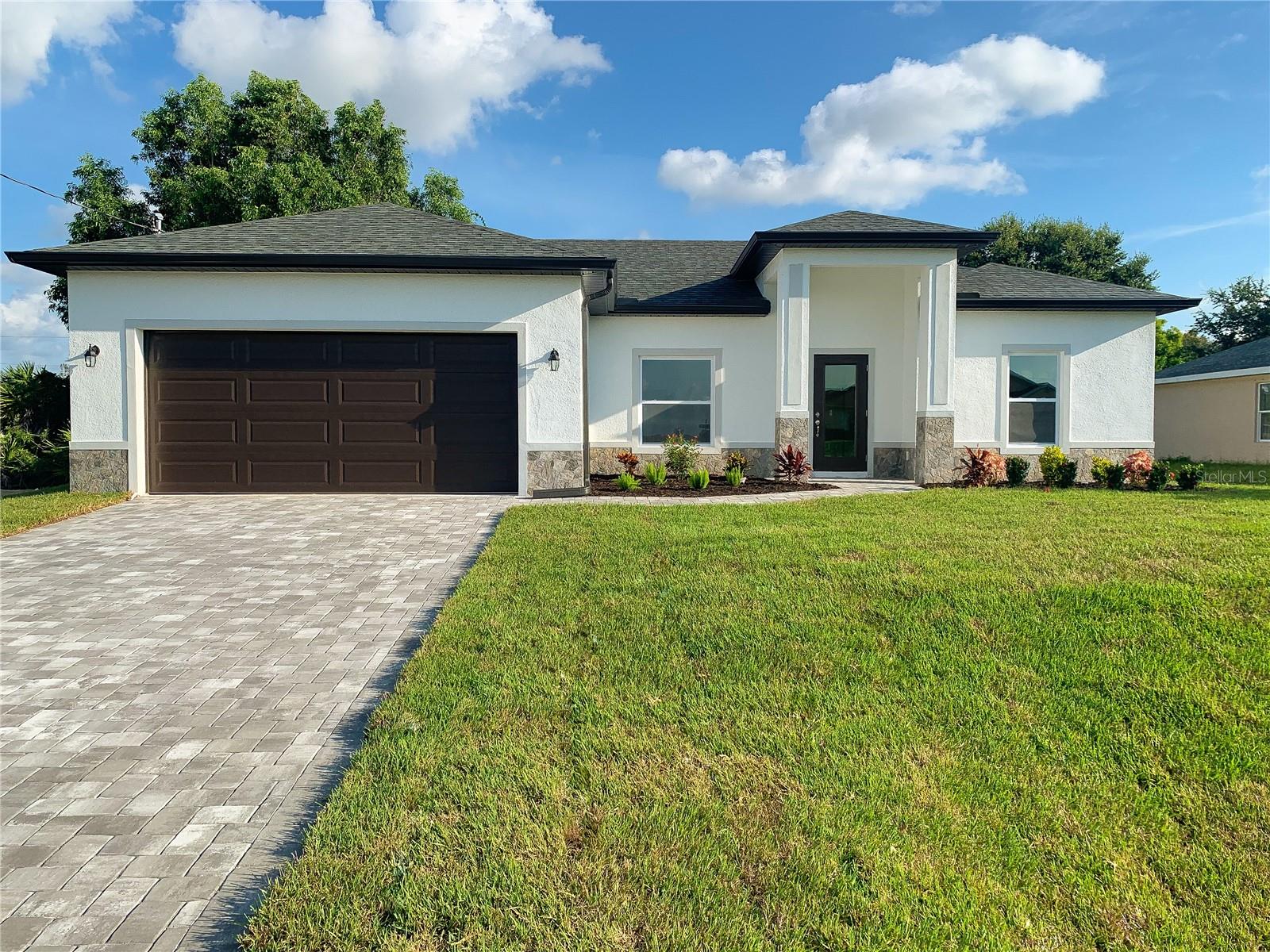 NEW CONSTRUCTION – MOVE IN READY! Closing cost incentives available! Beautiful split floor plan with hurricane impact, low-E windows and doors. Includes a full 1-year warranty and 10-year structural warranty. Prime location with a peaceful greenbelt view and no rear neighbors! Inside, enjoy an open layout, high tray ceilings, and elegant porcelain tile throughout. The bright living area opens to a generous covered lanai. The spacious kitchen is equipped with 42" upper cabinets, a pantry closet, and premium granite countertops. The primary suite features TWO walk-in closets and a gorgeous bathroom. Great outdoor area with irrigation system and upgraded landscaping. The front is tastefully finished with stone accents and a brick paver driveway. Additional features include a decorative impact-glass front door, extra linen closets, interior window sills, high-efficiency A/C system, Moen shower valves, and dimensional shingles. Great opportunity to own a brand-new home that’s efficient, low-maintenance, and loaded with upgrades!
