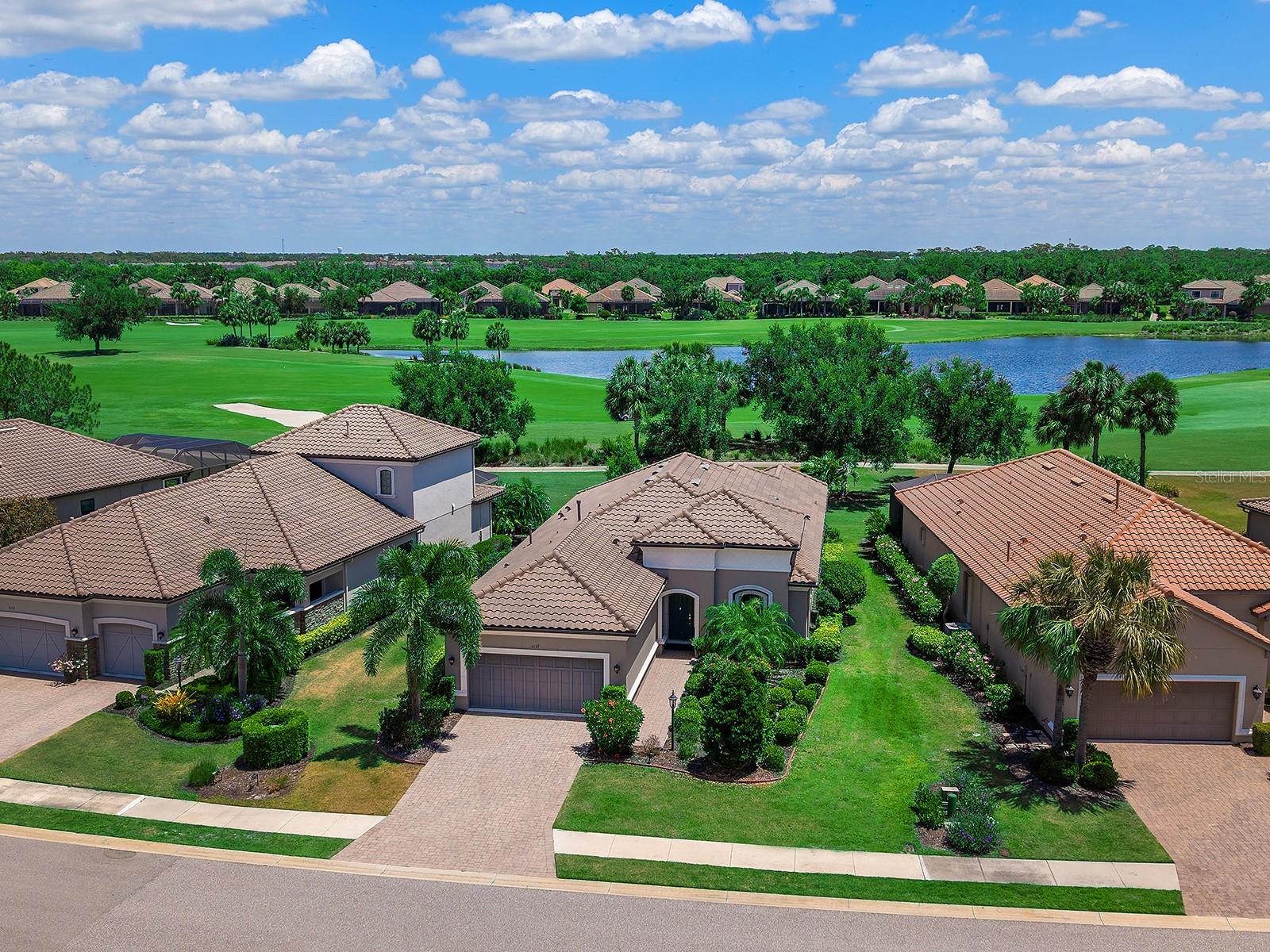 One or more photo(s) has been virtually staged. GOLF INCLUDED SINGLE FAMILY HOME NOW WITH NEW PRICING at $799,000.  Lowest priced deeded golf home in Esplanade Golf and Country Club at Lakewood Ranch! Golf country club living reaches new heights in this exceptional Taylor Morrison's Farnese VII floor plan, ideally in the prestigious Esplanade Golf & Country Club at Lakewood Ranch. Set on a premium homesite, this residence captures breathtaking panoramic water and dual fairway views of the 2nd and 17th holes, offering a daily backdrop of serene resort-style beauty. Spanning over 2,100 square feet of thoughtfully designed single-level living, this light-filled home features two bedrooms, 2.5 baths, a versatile den and a rare three-car tandem garage. From the moment you enter, soaring ceilings, 12-foot tray details, and expansive living spaces create an atmosphere of refined elegance. Luxury vinyl flooring flows seamlessly throughout, while sliding glass doors, abundant windows, solar tubes and custom lighting bathe the interiors in natural light. The gourmet chef’s kitchen is stunning and functional, showcasing custom cabinetry, elegant quartz countertops, a glass-tile backsplash, a spacious pantry and premium GE Café stainless steel appliances. A large center island with cabinets surrounding anchors the space, ideal for entertaining or casual dining. Indoor and outdoor living blend effortlessly as sliding doors open to a spectacular screened lanai, your private retreat with boundless room for seating or dining. An expansive covered patio and fully equipped outdoor kitchen with refrigerator, sink and gas grill set the stage for unforgettable gatherings, all framed by tranquil golf course and water vistas. There is ample room to design your dream pool and elevate the outdoor experience even further. The luxurious owner’s suite is a peaceful sanctuary featuring bay windows, a tray ceiling and a spa-inspired bath with stone countertops, dual vanities, a walk-in shower and an expansive custom California Closet system with built-ins, shelving and exceptional storage. The guest suite offers its own en-suite bath, complete with a soaking tub, ensuring comfort and privacy for visitors. A versatile den with French glass doors and plantation shutters provides space for a home office or flex space. Additional highlights include a formal dining room with tray ceiling, a stylish powder room, an oversized laundry room with custom cabinetry, sink, and LG washer and gas dryer, crown molding throughout, plantation shutters, and hurricane shutters and accordion shutters. This golf-deeded property conveys VIP membership, granting priority tee times and access to world-class amenities. Residents enjoy two stunning clubhouses, resort-style pools and hot tubs, fire pits, a waterside veranda, state-of-the-art fitness centers, pickleball and tennis courts, bocce, a driving range and putting green, a full-service spa and salon, playground, dog park, and a vibrant social calendar with live music and events. Dining options include the Barrel House restaurant overlooking the 18th fairway and the Bahama Bar & Grill at the main pool. Maintenance free - mowing, irrigation and landscaping included with HOA. Ideally near University Town Center, Waterside Place at Lakewood Ranch, Lakewood Ranch Main Street, St. Armands Circle, and the world-renowned beaches of Siesta Key, Lido Key, this guard-gated community offers the ultimate in convenience, luxury and lifestyle. This is more than a home, it’s a   resort experience.