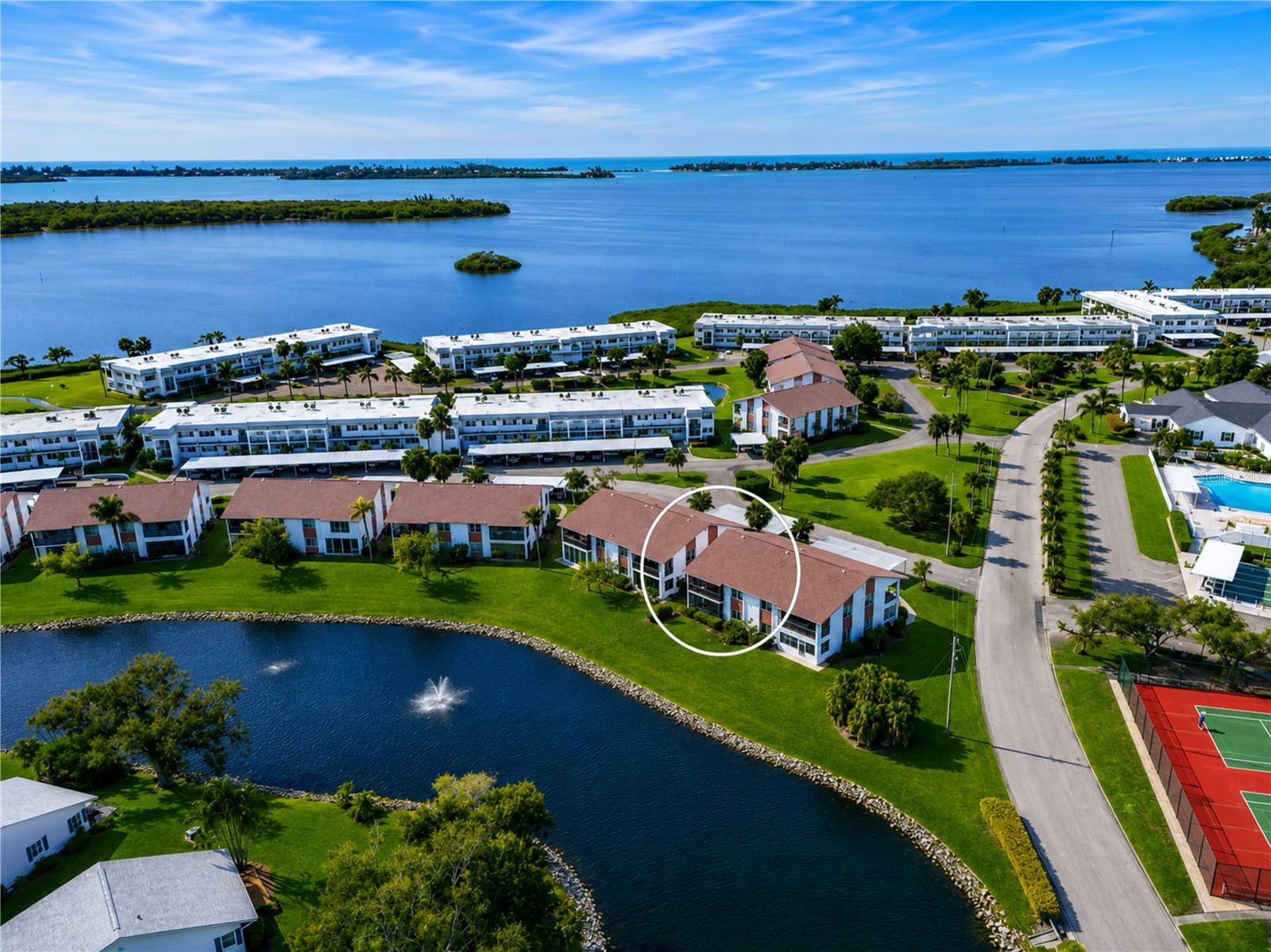 WELCOME TO THIS EXCEPTIONAL FIRST-FLOOR TURNKEY FURNISHED LAKEFRONT CORNER CONDO located in a highly sought-after bay and canal-front community where comfort, value, and resort-style living blend beautifully together. Offering the community’s largest two-bedroom floor plan, this thoughtfully upgraded residence is perfectly positioned in the center of the community just steps from the clubhouse and amenities, while enjoying peaceful water, fountain and nature views, abundant natural light, and the added privacy of a desirable corner location. BUILT WITH SOLID concrete block construction, a 2019 roof and impact windows, this inviting condo immediately captures your attention with its bright, airy atmosphere and open-concept design. Fresh interior paint, smooth textured ceilings, six-panel doors, updated ceiling fans with remotes, and attractive plank flooring throughout create a clean coastal feel that is both stylish and welcoming. Tile flooring in the foyer, kitchen, and lanai adds durability and ease of maintenance, while generous storage throughout the home enhances everyday living. THE SPACIOUS living and dining room combination offers beautiful lake views and exceptional flexibility for furniture placement and entertaining. Sliding glass doors open to the expansive 17’ x 8’ screened lanai where tranquil water and nature views create the perfect setting for morning coffee, outdoor dining, or simply relaxing and enjoying the Florida lifestyle. The tiled lanai also offers potential space outside for adding patio pavers to further extend your outdoor living area. THE FULLY EQUIPPED KITCHEN has been tastefully updated with white cabinetry accented by matte black hardware, a stainless-steel appliance suite, breakfast bar, closet pantry, and an eye-catching tray ceiling featuring remote-controlled LED uplighting that adds warmth and ambiance to the space. DESIGNED WITH PRIVACY in mind, the split-bedroom floor plan separates the bedrooms and bathrooms with a private hallway, creating comfortable accommodations for both owners and guests. The spacious primary suite enjoys calming water views, room for a king-size furniture suite, two large closets, and an ensuite bathroom featuring dual updated vanities, fixtures, mirrors, and lighting. Situated toward the front of the condo, the generously sized guest bedroom offers a walk-in closet and convenient access to the tastefully updated guest bathroom, creating a welcoming retreat for family and visitors alike. ADDITIONAL CONVENIENCES include a carport located directly out front at the end of the sidewalk and turnkey furnishings included for immediate enjoyment, excluding only personal items and select decor accessories. RESIDENTS ENJOY an active and friendly community filled with amenities and surrounded by natural beauty. The maintenance-free lifestyle allows you more time to enjoy boating, beaches, dining, shopping, social activities, and everything the Florida Gulf Coast has to offer. THE ASSOCIATION DUES PROVIDE TREMENDOUS VALUE and cover water, sewer, trash, recycling, pest control, cable, internet, exterior maintenance and repairs, landscaping, and insurance. Mt Vernon on Sarasota Bay is known for its amenity-rich, maintenance-free lifestyle and exceptional value. WHETHER YOU ARE searching for a full-time residence, seasonal getaway, or investment in the Florida lifestyle, this beautifully maintained waterfront condo offers an exceptional opportunity that buyers will not want to miss.