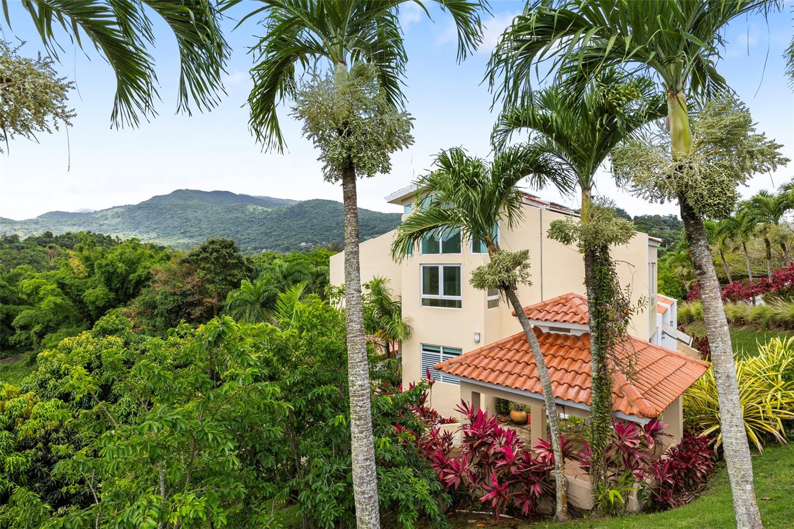 Set across two combined parcels within the private gated community of Hacienda Carabalí, and just moments from El Yunque National Forest, this unique equestrian estate offers a rare blend of privacy, natural beauty, and income potential. The main residence features 3 bedrooms, 3 full indoor bathrooms, plus an additional outdoor full bath on the lower terrace, ideal for entertaining. A separate two level casita provides excellent flexibility for guests or short-term rental income, with a kitchen, dining area, and full bath upstairs, and a living room, bedroom, and full bath on the lower level. Designed with equestrian living in mind, the property includes a four-stall stable, wash area, tack room, and storage. The stables are ready for customization or rehabilitation to suit the next owner’s vision. The grounds also feature new fencing, two paddocks, and direct access to the scenic Carabalí horse trails. Surrounded by lush, mature fruit trees including banana, soursop, starfruit, mango, guava, and papaya! The property offers a true tropical retreat experience. Recent upgrades include a solar energy system with three Tesla backup batteries, reinforced perimeter fencing, updated lighting, new appliances, refreshed interiors, and split A/C units throughout both the main home and casita. Whether as a private retreat, equestrian haven, or income-producing short-term rental, this property presents a rare opportunity in one of Puerto Rico’s most sought-after natural settings.