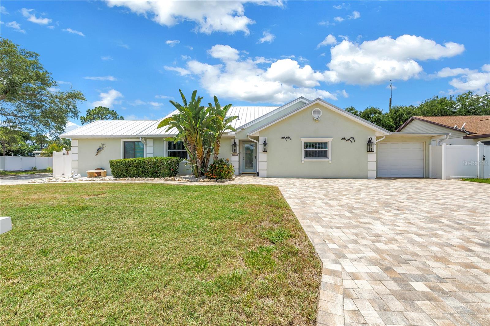 Looking for a home that actually gives everyone their own space without sacrificing comfort, style, or togetherness? This beautifully updated true 3 bedroom, 3 bath home was designed for real life! Whether you have a growing family, multi-generational living needs, frequent guests, teenagers wanting privacy, or simply need room to spread out and enjoy life comfortably. This home allows it all.

Situated on an oversized corner lot on a quiet partial cul-de-sac, this over 2,000 sq ft home offers a layout that is incredibly hard to find. What makes this property even more special is that every bedroom feels like its own private retreat with en-suite style living, thoughtful separation throughout the home, and beautifully updated bathrooms that bring a modern touch to every space.

The sellers carefully transformed the layout to create flexible living spaces that work perfectly for today’s modern families. The original primary bedroom was converted into a private mother-in-law suite complete with its own private entrance, kitchenette, en-suite bath, extra storage and closet space, dedicated mini split AC system, and even private parking directly outside the entrance, allowing guests or family members to come and go without disturbing the rest of the home. It’s the perfect setup for extended family, aging parents, adult children, long-term guests, or even additional income opportunities.

At the same time, the original garage was beautifully converted into an expansive new primary suite featuring a walk-in closet and a stunning updated walk-in shower, creating a peaceful and luxurious space completely separate from the rest of the home.  A third spacious bedroom also offers direct access to the pool area through the bathroom, making it easy for family and guests to use the restroom after swimming without ever needing to walk through the house — a thoughtful feature perfect for entertaining and everyday Florida living.

Outside is where this property truly comes to life. The resurfaced heated saltwater pool surrounded by gorgeous pavers creates the ultimate backyard gathering space. From summer pool days and family celebrations to relaxing evenings under the stars, this backyard was made for making memories. The beautiful pavered driveway and extensive hardscaping not only add incredible curb appeal but also provide an abundance of parking space for multiple vehicles, guests, boats, or recreational toys.

The sellers also added a covered two-car carport/garage complete with a garage door and EV charging station, giving even more flexibility and convenience.

Beyond the beauty and functionality, the home also offers peace of mind with major updates already completed including all impact windows, a metal roof installed in 2020, and a new electrical panel in 2021.

Homes offering this much flexibility, privacy, entertaining space, parking, and thoughtful updating rarely become available in such a desirable neighborhood. This is more than just an updated home — it’s a property designed to truly fit the way families live today while giving everyone a place to call their own.