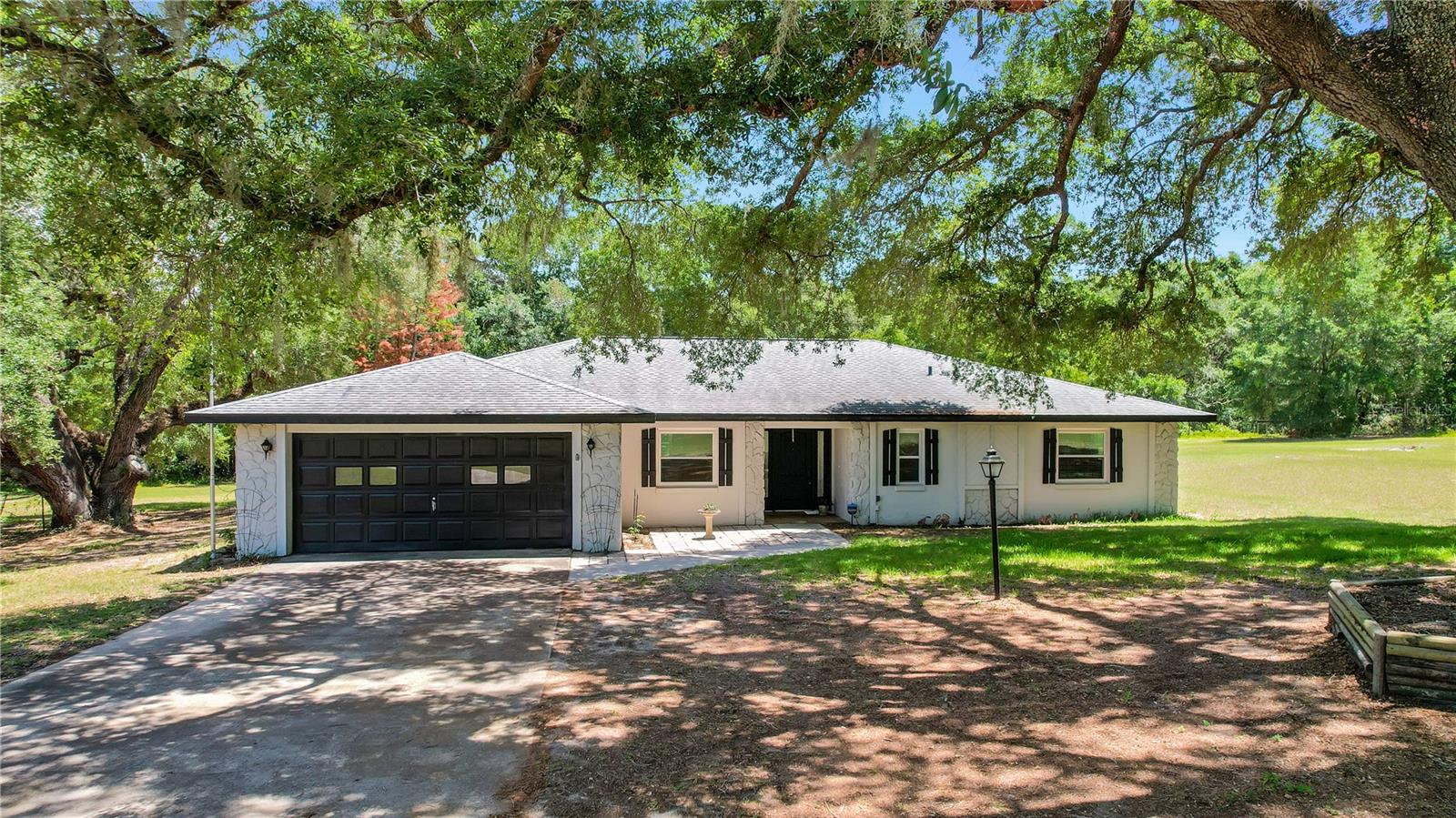 Escape to peaceful country living in this beautifully updated 4-bedroom, 2-bathroom POOL home situated on 3 private acres in Weirsdale. Inside, you’ll find gorgeous engineered hardwood floors, sleek tile flooring, a desirable split floor plan, and stunning views overlooking the pool area. The updated kitchen features stainless steel appliances, granite countertops, stylish white cabinetry, custom molding, and a modern tile backsplash. The oversized primary suite offers tons of space, a large walk-in closet, and an updated en suite bathroom complete with a spacious walk-in shower. An added bonus is the 4th bedroom/craft room/den which is oversized but does not have a closet. Additional highlights include an interior laundry room and an oversized garage. Step outside to enjoy your expansive pool deck, large pool (20'x40') and fully fenced pool area, perfect for entertaining or relaxing in your own private retreat. Major upgrades provide peace of mind, including all new low-emissivity double-pane windows and sliding glass door in 2015 with a transferable lifetime warranty, new roof in 2020, pool resurfacing in 2016, new water heater in 2024, and a brand new HVAC system in 2025. Conveniently located just 10 minutes from shopping, dining, and The Villages, this property offers the perfect blend of privacy, comfort, and convenience.