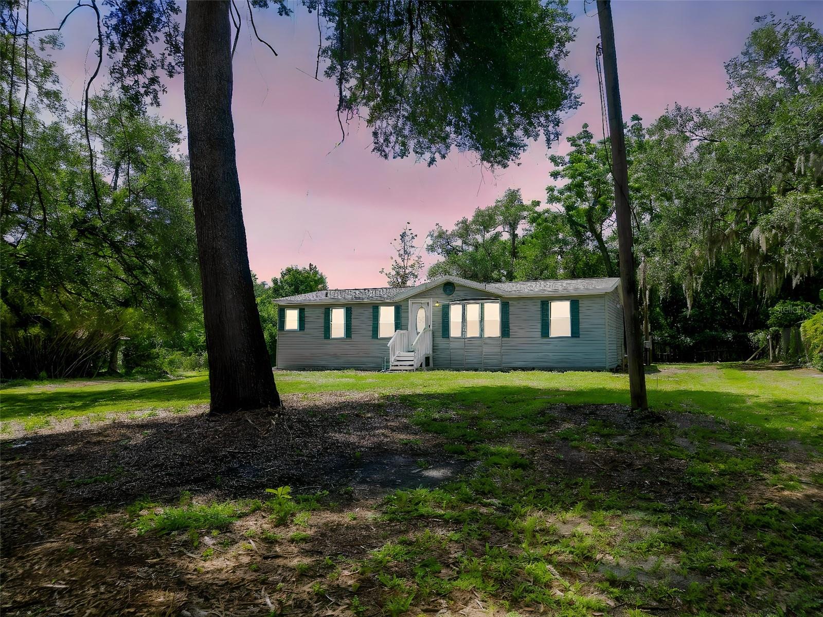 One or more photo(s) has been virtually staged. Price improved!!  This is a rare find sitting on nearly a full acre in Lutz with NO HOA, NO CDD, and no flood zone, and is fully move in ready for its next owner to call home. This north facing double wide was built in 2001 and sits on a concrete slab, giving you the space, freedom, and privacy that is getting harder to find in Tampa Bay. 
Inside you’ll find new laminate flooring, blinds, lots of natural light, and a functional layout ready for everyday living. The home is built on a  also features a water softener system and a screened in lanai, also built on a concrete slab, overlooking the backyard and pond view. Spend your evenings fishing right from your own backyard while enjoying the peaceful setting this property offers.
The fenced yard creates separation from neighboring properties and gives you endless possibilities with room for trucks, trailers, boats, RVs, pets, gardening, future additions, or even building the garage or workshop you’ve always wanted. There is already an electrical hookup in place for an RV, making it easy to store your toys and enjoy the property without the restrictions of an HOA telling you what you can and cannot do. The property is zoned AS-1 (Agricultural Single Family) allowing the owner the ability to keep livestock such as horses or cattle, poultry, and even enjoy small scale farming or horticultural use. While AS-1 zoning allows only one single family residence per parcel, it still provides far more flexibility and usable land options compared to many standard residential neighborhoods in the area. Property owners can typically build additional detached structures such as barns, stables, greenhouses, workshops / garages, giving you even more ways to maximize the land and create your ideal dream setup. There is immense value in having this type of zoning, land, and flexibility this close to the city, especially as properties with usable acreage continue to become harder to find in Tampa Bay.
Icing on the cake, directly across the street is the Violet Cury Nature Preserve with over 160 acres of trails and nature views, while still being conveniently located near Bearss Ave and I275 for an easy commute. Roof fully replaced in 2021. Whether you want space to spread out, enjoy a more rural lifestyle, or invest into land without heavy restrictions, this property checks all the boxes. Schedule your showing before it’s gone.