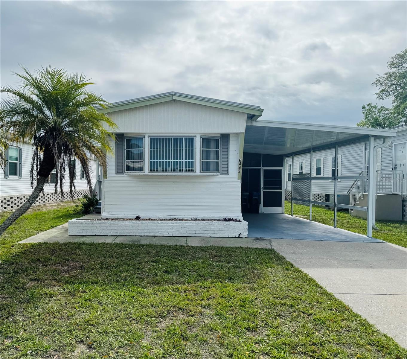 Welcome to 6442 Hikina Drive in North Port, Florida—a beautifully maintained, **TURNKEY 2-bedroom, 1.5-bath home** located in the highly sought-after 55+ gated community of Holiday Park. This home features a desirable split floor plan, offering added privacy with the primary bedroom situated at the rear of the home. Thoughtfully updated, the property includes updated membrane roof (2023), new subfloors (2023), vinyl plank flooring (2023), and water heater (2023)—providing peace of mind and modern comfort for years to come.
Holiday Park is a premier land-owned, deeded community, meaning you own both the home and the land. The low monthly maintenance fee of just $195 ($2,340 annually) is conveniently included in your property taxes.

Residents enjoy an exceptional lifestyle with access to clubhouses, swimming pools, fitness center & library, tennis, pickleball & bocce courts, shuffleboard, horseshoes, ping pong, and social gathering spaces, & more. Set within a beautifully landscaped, park-like environment, Holiday Park is perfect for active living and vibrant social opportunities. Ideally located, you’re just minutes from shopping, dining, entertainment, golf courses, sports facilities, and the stunning Gulf Coast beaches of Southwest Florida.
Move right in and start enjoying the Florida lifestyle—schedule your showing today!