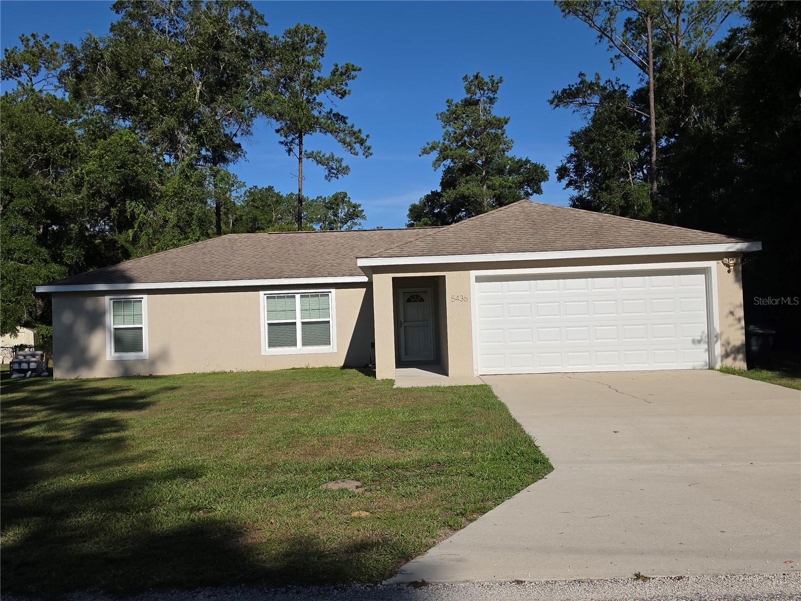 Available now! This well-maintained 3-bedroom, 2-bath home offers a functional split-bedroom floor plan, an attached 2-car garage, and comfortable living spaces throughout. The spacious living room flows into the dining area, where sliding glass doors lead to an open rear patio and backyard.  The kitchen features stainless steel appliances, a pantry, and ample cabinet space. The primary suite includes a walk-in closet, dual sinks, a walk-in shower, and a private linen closet. The guest bedrooms offer generous closet space, while ceramic tile in the kitchen and bathrooms and carpet throughout the remaining living areas provide a practical combination of comfort and convenience.  Conveniently located in Ocala Park Estates with easy access to I-75 and US Hwy. 27, this home is just minutes from shopping, dining, schools, and everyday amenities.