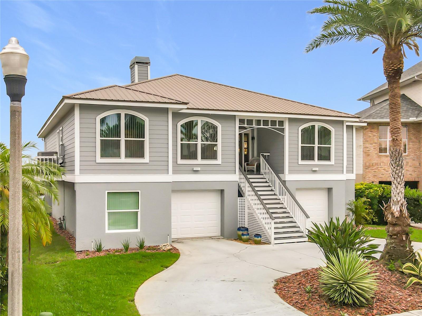 Welcome to your own slice of waterfront paradise in the highly sought-after Pointe Alexis community, where elevated coastal living harmonizes with luxury comfort and everyday tranquility. From the moment you arrive, this beautifully maintained and thoughtfully updated home makes an unforgettable impression with its striking curb appeal, tropical landscaping, and timeless metal roof.

Step inside to discover soaring ceilings, rich wood flooring, and abundant natural light that fills the open-concept living spaces, creating a warm yet inviting atmosphere. The impressive great room is the heart of this home, designed for making cherished memories with family and friends. With its inviting layout and breathtaking coastal backdrop, you can admire stunning water views from nearly every angle, creating the perfect ambiance for relaxation, entertainment, and unforgettable gatherings.

The stunning chef’s kitchen, a seamless extension of the great room, features extensive custom cabinetry, granite countertops, stainless steel appliances, gas range, oversized breakfast bar seating, and exceptional storage—ideal for both entertaining and daily living.

Enjoy the seamless transition to the screened-in patio area, where you can relax while taking in panoramic views of the intercoastal—perfect for outdoor dining or unwinding in your own private retreat. The spacious primary ensuite is a true sanctuary, featuring ample room and those captivating "pinch-me" views, ensuring every morning feels like a dream come true.

Venture downstairs to discover an open canvas waiting for your personal touch—perfect for a home office, gym, or additional storage, allowing you to customize the space to fit your needs.

Pointe Alexis provides a true resort-style lifestyle with access to a clubhouse, community pool, tennis courts, and impeccably maintained surroundings—all just minutes away from beautiful beaches, marinas, waterfront dining, shopping, and the renowned Tarpon Springs Sponge Docks.

Whether you seek a full-time coastal retreat or the ultimate Florida getaway, this exceptional waterfront home delivers the perfect blend of elegance, comfort, and vibrant lifestyle—an extraordinary opportunity to live the life you’ve always dreamed of.
