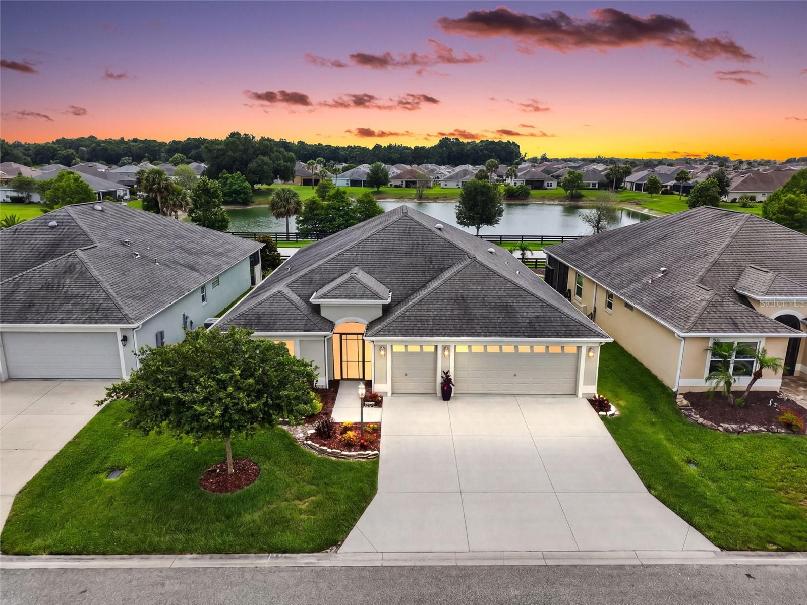Experience the best of Florida living in this BEAUTIFULLY-MAINTAINED 3/2 Designer Iris boasting AMAZING WATER VIEWS, 714sf GLASS-ENCLOSED LANAI with TWO MINI-SPLITS, REAR PAVER PATIO, and OVERSIZED 618sf TWO CAR + GOLF CART GARAGE located in the Village of Fenney! TROPICAL landscaping with stone-edged beds, SCREENED entry vestibule, and LEADED GLASS door and sidelights welcome you into a GENEROUS foyer with a convenient ENTRY CLOSET. An EXPANSIVE OPEN CONCEPT floor plan showcases rich wood-grain LUXURY VINYL PLANK flooring, CUSTOM-TRIMMED ARCHED doorways, EXTENDED baseboards, and HIGH VAULTED ceilings creating a VOLUMINOUS main living area with TWO SOLAR TUBES for ABUNDANT NATURAL LIGHT. The STUNNING kitchen is thoughtfully designed with rich ESPRESSO SHAKER cabinetry, elegant veined QUARTZ countertops, GLASS TILE backsplash, and STAINLESS appliances with GAS cooking. Additional highlights include a MOVEABLE CENTER ISLAND, BUILT-IN DOUBLE PANTRY, ROLL-OUT shelving, UNDER-CABINET lighting, and EAT-IN breakfast bar with adjacent dinette for casual dining. From both the living room and dinette, CORNICE-ADORNED doorways lead into the SPECTACULAR 714SF GLASS-ENCLOSED LANAI - an extraordinary extension of the living space designed for year-round enjoyment! This INCREDIBLE retreat boasts INCREDIBLE WATER VIEWS, TWO MINI-SPLITS, DOUBLE-PANED HURRICANE GLASS windows, REMOTE-CONTROLLED SOLAR shades, THREE ceiling fans, and DECORATIVELY PAINTED floors. It seamlessly extends to a SPACIOUS PAVER PATIO, creating the perfect setting for grilling, outdoor dining, entertaining, or simply enjoying Florida’s sunshine while overlooking SERENE WATER VIEWS! Back inside, the luxurious primary bedroom boasts a TRAY ceiling, LVP flooring, FOUR windows, and CUSTOMIZED WALK-IN closet. Its en-suite bathroom features TILE flooring, VAULTED ceiling, ESPRESSO corner cabinetry with veined QUARTZ top, DUAL sinks, TILE ROMAN-STYLE WALK-IN shower, built-in LINEN closet, and a separate water closet. Two additional bedrooms and a second bathroom are located behind a POCKET DOOR near the front of the home, ensuring plenty of PRIVACY for guests or a quiet home office. Bedroom two boasts a TRAY ceiling, LVP flooring, DOUBLE windows, and built-in closet. The second bathroom has TILE floors, ESPRESSO vanity with veined QUARTZ top, TILE tub/shower combo, and hall LINEN closet. Bedroom three offers a VAULTED ceiling, LVP flooring, and a built-in closet. An INTERIOR laundry room features TILE floors, shelving, ESPRESSO cabinetry, and built-in utility sink with veined QUARTZ top. The EXPANSIVE 618sf TWO-CAR + GOLF CART GARAGE features a Pegasus water softening system and ABUNDANT space for PARKING and STORAGE! The Village of Fenney is IDEALLY LOCATED with Brownwood Paddock Square JUST ACROSS the Water Lily Bridge; Sawgrass Grove and Eastport Town Square only short golf cart rides away; Also close to Fenney Recreation Center, pool, and the FAMOUS OAK HAMMOCK Nature Trails; Sugar Cane, Blue Heron, and Willow Tree Recreation Centers; Everglades Regional Recreation Center; Dudley Canine Park and Archery Range; Red Fox, Gray Fox, Lowland, Longleaf, and Loblolly Executive Courses; Fenney Putt and Play; and Fenney Grill for your dining pleasure! Close by are Magnolia Plaza and SR44 for abundant shopping, dining, medical, banking, and more! PLEASE WATCH OUR WALKTHROUGH VIDEO of this MAGNIFICENT HOME in a FABULOUS LOCATION and call today to schedule your Private Showing or Virtual Tour!