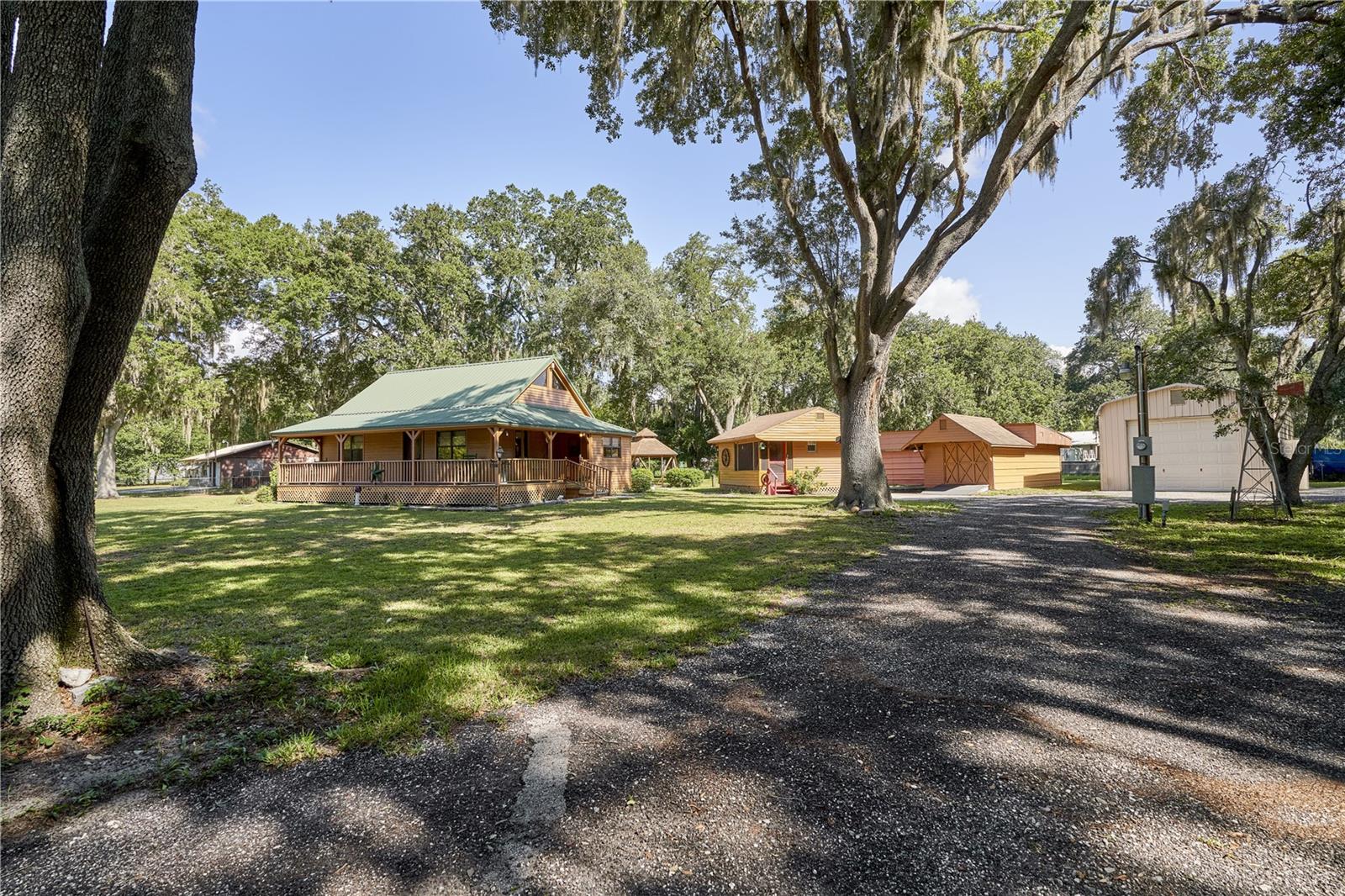 IMPRESSIVE AND UNIQUE CUSTOM-DESIGNED AND CUSTOM-BUILT HOME. THE Architectural EXTERIOR FEATURES OF THE MAIN HOUSE ARE A DRAMATIC AND STRIKING METAL ROOF DESIGN, WOOD EXTERIOR AND INVITING WRAP AROUND PORCH.   ALL SITUATED ON A TRANQUIL TREED 1 ACRE LOT.   THE INTERIOR OF THE MAIN HOUSE IS WARM AND INVITING.  YOU STEP INTO BREAKFAST ROOM WHICH LEADS TO AN OPEN KTICHEN WHICH OVERLOOKS THE GREAT ROOM LIVING ROOM.  LOTS OF WINDOWS AFFORD THE INTERIOR A LIGHT AND BRIGHT FEEL.  WARM WOOD TOUCHES WHICH INCLUDE EXPOSED WOOD BEAMS, SOLID PLANKED INTERIOR DOORS AND A STRIKING WOOD STAIRCASE WHICH LEADS TO THE SECOND FLOOR.  MASTER BEDROOM IS DOWNSTAIRS.  IT IS NICE SIZED AND HAS A WALK-IN CLOSET.   MAIN FLOOR BATHROOM IS AMPLE AND FEATURES A SHOWER, VANITY AND A PLACE FOR A STACKABLE WASHER/DRYER.   THE PROPERTY FEATURES ADDITIONAL STRUCTURES.......  FIRST A QUAINT GUEST COTTAGE WITH BEDROOM SPACE, SITTING AREA, SCREENED ENTRY AND A HALF BATH......  AN UNBELIEVABLE RV GARAGE WITH ELECTRIC GARAGE DOOR AND PEDESTRIAN DOOR.  APPROXIMATE SIZE IS 45 LONG BY 19 WIDE.  PROTECT YOUR RV AND PARK IT IN A SECURE GARAGE.....  NEXT, WE HAVE THE OVERSIZED GARAGE/WORKSHOP.  26 FEET IN LENTH AND 24 FEET WIDE.  IT PROBALBY CAN HOUSE UP TO 4 CARS.  IT FEATURES A CUSTOM-BUILT INTERIOR WRAP AROUND WORK BENCH AND SPACE FOR ANY USE. .....  CAR STORAGE, HANDYMAN WORKSHOP, ANTIQUE RESTORATION.  A CREATIVE SPACE FOR A HOBBYIST AND OR ART.   REMOTE CONTROL GARAGE DOOR ENTRY AND AGAIN A PEDESTRIAN ENTRY.  
A SEPARATE BUILDING WHICH AFFORDS A RAMP ENTRY FOR A MOTORCYCLE OR ATV.  PROVIDING ROOM TO STORE AND WORK ON YOUR MOTORCYCLE OR ATV.  ATTACHED TO THE MOTORCYCLE GARAGE IS ANOTHER GOOD-SIZED STORAGE SPACE WHICH HAS ITS OWN ENTRY......  A CHARMING OUTDOOR GAZEBO....  A CIRCULAR DRIVEWAY AFFORDS ACCESS TO ALL THE MAIN STRUCTURES.  A BRAND-NEW SEPTIC SYSTEM INSTALLED IN JUNE/JULY OF 2026.  A COMPLETELY FENCED YARD.  BEAUTIFUL TREES AND NATURE SETTING.  YET THE PROPERTY IS CLOSE TO ALL THAT WESLEY CHAPEL HAS TO OFFER AND PROVIDES QUICK ACCESS TO HIGHWAY 54 AND I-75.
PROPERTY IS BEING SOLD "AS IS".  ALL MEASUREMENTS SHOULD BE VERIFIED.   PROOF OF FUNDS ON A LENDING INSTITUTION LETTERHEAD FOR A CASH TRANSACTION OR A LETTER OF PREAPPROVAL FOR A FINANCING TRANSACTION.