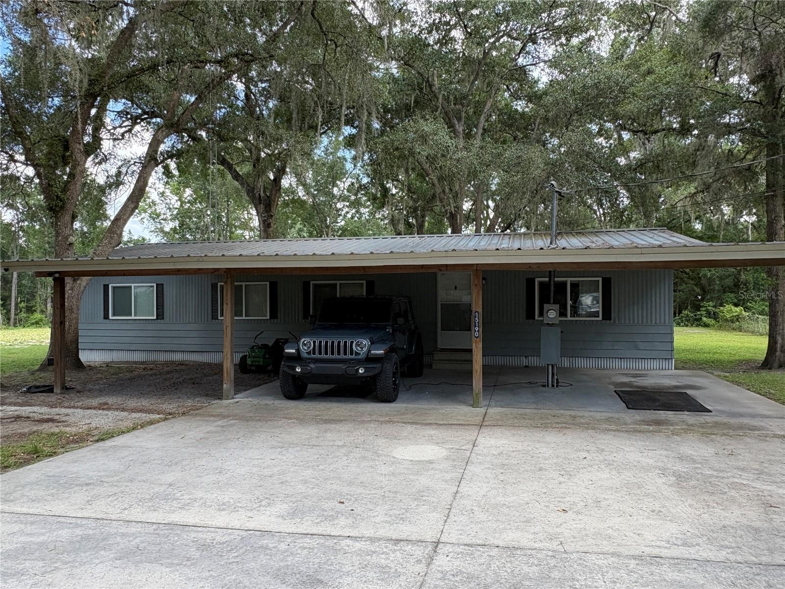 1974 mobile home in good condition on over 1 acre with 5 carport spaces and a concrete driveway. The property is fully fences and cleared and backs up to a wooded area for extra privacy. On the inside, you will fins 2 large bedrooms and 2 bathrooms. The primary bedroom has a walk in closet and can easily accommodate a king bed. The 2nd and 3rd bedroom have been combined into one large bedroom but could easily be converted back into 2 bedrooms. The house has a covered front with 3 carport spaces and a concrete slab and an additional detached 2 car carport. There is a screened in back porch also. The property has 2 working wells. The HVAC was replaced in 2020 and it has a metal roof. Set up your showing soon because this property will not last long.