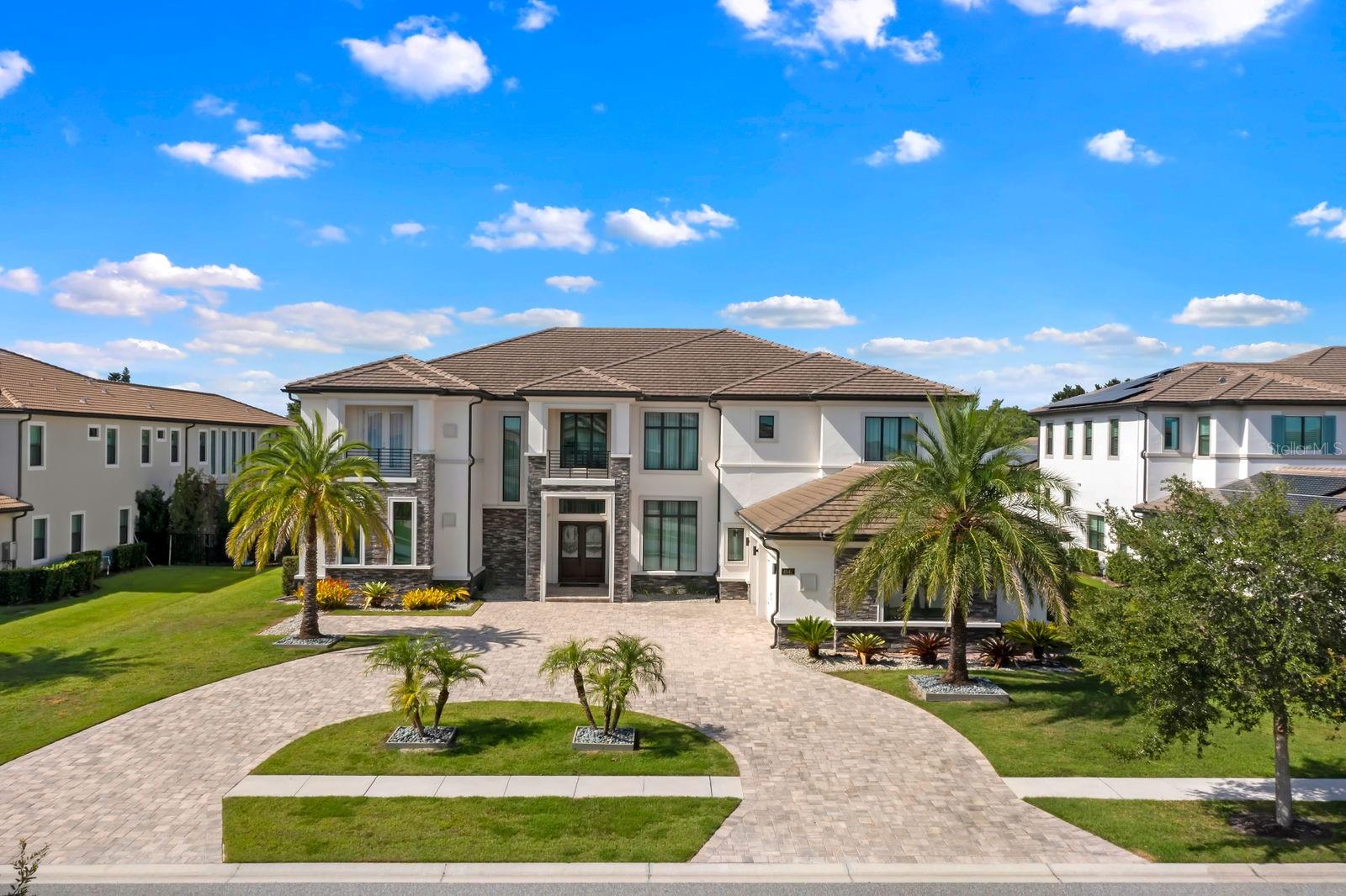 $75,000 credit towards pool with acceptable offer! This exceptional 2019-built home has been transformed with nearly a full interior remodel, making it one of the most distinctive properties in the sought-after Windermere community of Casabella. As the largest model in the neighborhood, this home offers a rare blend of space, style, and function. Inside, thoughtful upgrades abound. A dramatic 24-foot fireplace with imported porcelain slabs is a stunning centerpiece in the main living area. The main level features oversized imported porcelain tile, upgraded baseboards, and enhanced door designs that elevate the overall aesthetic. Multiple recessed ceilings with integrated LED lighting and modern spotlights create a warm, inviting ambiance throughout. Curtains with built-in lighting add a subtle, sophisticated touch. The first-floor primary retreat offers double doors, a backlit tray ceiling, abundant closet space, a raised soaker tub, dual sinks, and clean linen finishes. The kitchen stands out with a sleek, modern design made entirely of imported cabinetry, paired with top-of-the-line appliances—including a Sub-Zero fridge, Wolf double oven, gas stove, microwave, and hood, plus a JennAir dishwasher. Quartz countertops flow through the kitchen and all bathrooms, which are finished with imported porcelain tile, linear drains, and LED-lit niches. Upstairs, you'll find a blend of wood accents that bring warmth to the bedrooms, loft, and theatre. The home theater is also prewired for LED lighting and motorized seating. Outside, the large covered lanai is prepped for a summer kitchen, paired with plenty of yard space to create your own private escape. Modern, refined, and built to impress—this is Windermere living at its finest. Call today to set up a tour!