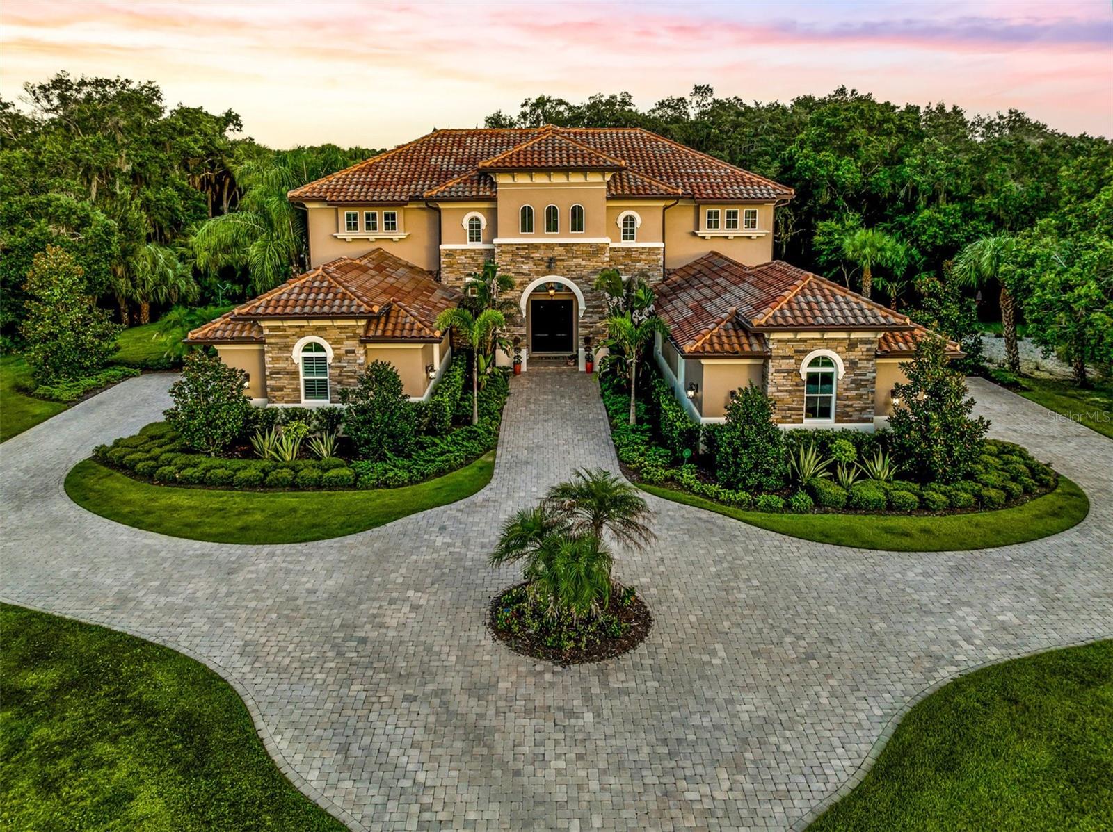 Welcome to the Forest at Hi Hat Ranch. The Forest is a private community of 54 total lots on over 270 acres in Sarasota, Fl with electronic
gates, a private Gazebo Park, and a no-repeat architecture rule – no two homes are alike within the community. This 5 bedroom 6 ½
bathroom estate home will wow you front moment you drive onto the paver driveway. The home sits on 4.3 acres of mature landscaping
and boasts 5.284 SqFt under air. This is a custom-built home with no details spared; including a four-car garage to meet all your storage
needs. Many custom features include draperies, remote blinds, and plantation shutters. This 2016 Mediterranean style home commands a
strong presence from the outside to the inside with 30-foot-high ceilings in the foyer to the enormous outdoor entertainment center. The
caged heated pool and spa includes a summer kitchen, fireplace, and multiple gathering areas for the best entertaining. Stylish flooring
throughout, unified with modern tile, wood, and luxury vinyl floors. Grand living room with soaring custom tray ceilings with view to pool
and lush backyard. Gorgeous kitchen with large cafe area and top of the line appliances including Thermador fridge/freezer, an ice maker,
huge butler’s pantry, wine fridge and wine closet. Propane (buried) services for cooktop, fireplace, and outdoor kitchen. The Bonus family
room upstairs includes kitchenette with dishwasher and accesses large second floor balcony for impressive views of property and caged
pool. Safety and security are built into this home with outdoor cameras, and Google home security system. In addition to landscaping lights and two HVAC systems zoned for efficiency. Connection for
independent gas-powered generator. If you are looking for privacy in a secure environment, look no further- the Forest at Hi Hat Ranch is
for you. Don’t wait; schedule your showing today of this estate home. 3D Matterport video available in virtual tour.