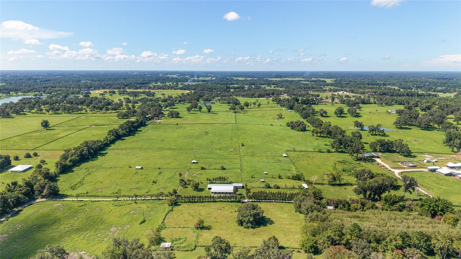 Welcome to Rolling Horizon Farm South, a breathtaking 44-acre horse farm nestled in the heart of southern Marion County—one of Florida’s most sought-after equestrian regions. Traveling along the paved, tree-lined driveway to the farm’s entrance, you’re surrounded by the natural beauty and serenity that defines this exceptional property.
Gently rolling pastures stretch across the landscape, bordered by mature trees that provide shade and privacy. A fully fenced perimeter and one expansive, fenced paddock make this an ideal setting for training, breeding, or simply enjoying wide-open space. Water lines run throughout the property for convenience and functionality.
At the heart of the property lies a thoughtfully designed combination center-aisle and shedrow barn, offering 24 stalls—some of which easily convert into foaling stalls—and a spacious recreational room complete with a full kitchen. Whether you're managing a breeding program or looking for a training facility to make your own, this barn is built to accommodate both horse and human needs in comfort and style.
With hilltop panoramic views, the property offers a stunning location for building your dream home or expanding the equine facility.
Perfectly located, Rolling Horizon Farm South is just minutes from the Florida Horse Park, offering trails for horseback riding, hiking, biking, and a robust calendar of equestrian events. You’re also a short drive from the World Equestrian Center and just 10 minutes from all the shopping, dining, and modern conveniences of The Villages.
This is more than a property—it’s a rare opportunity to have the equestrian lifestyle you’ve always dreamed of.